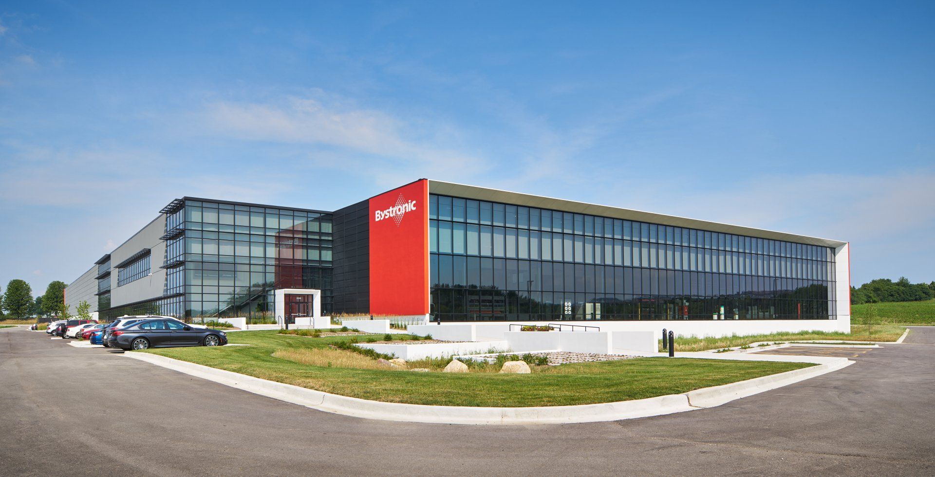 A large building with a lot of windows is sitting on the side of a road.
