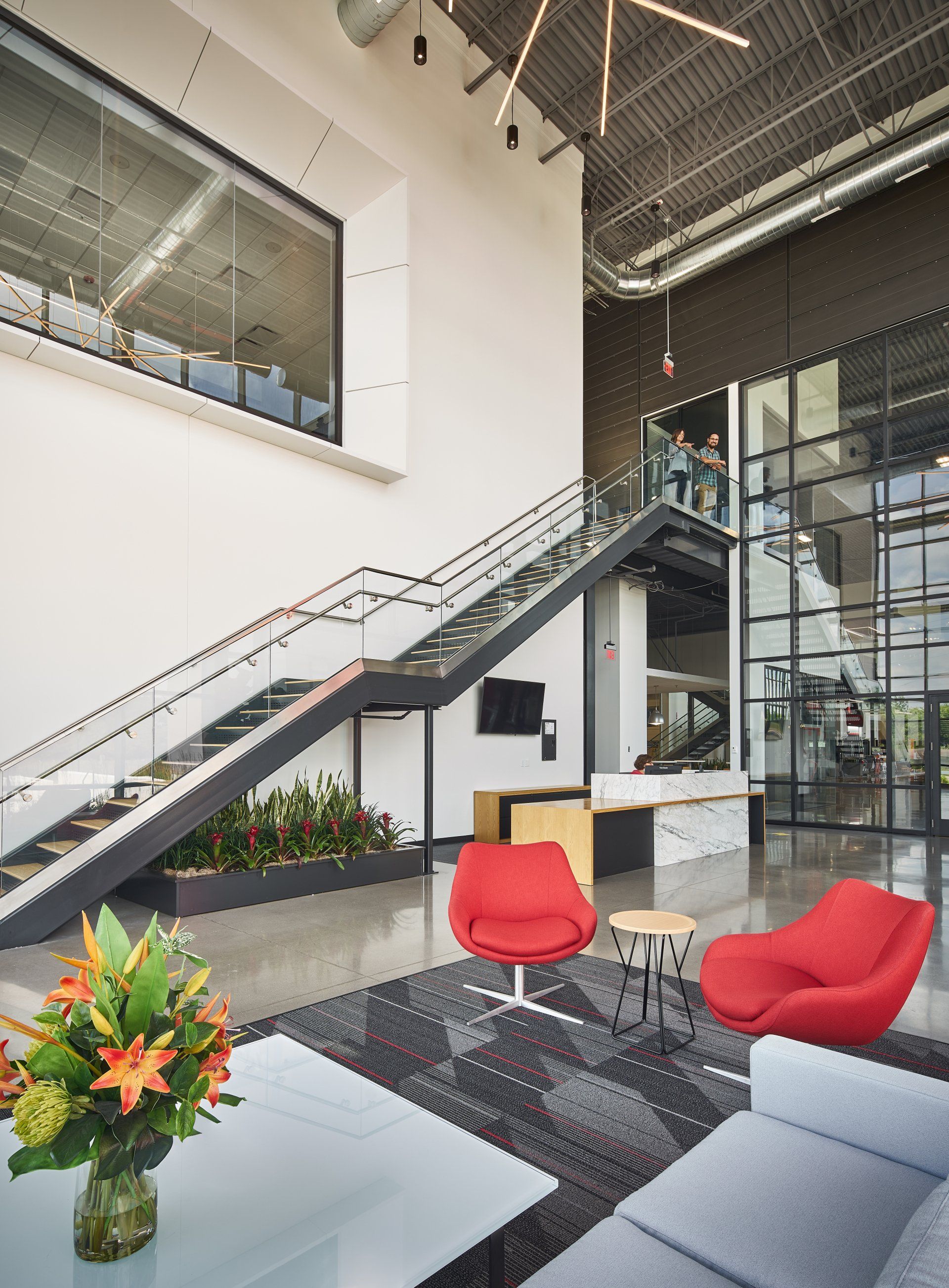 A living room with a couch , chairs and stairs