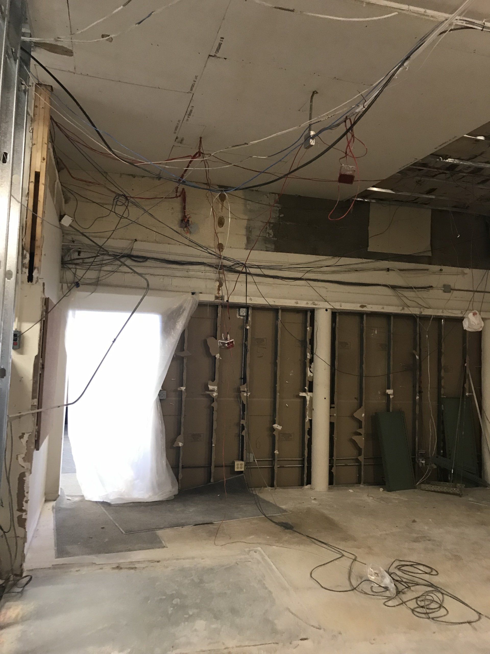 An empty room with a lot of wires hanging from the ceiling.