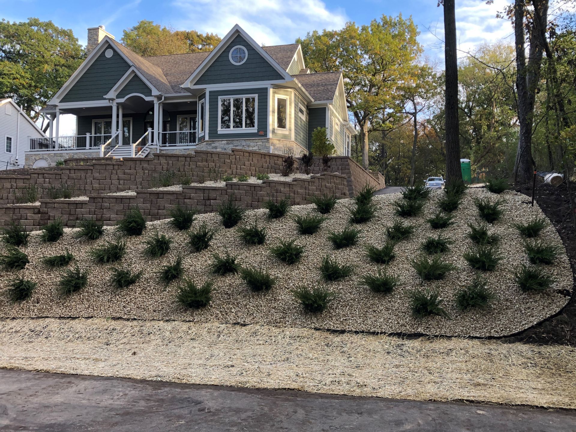 A large house is sitting on top of a hill surrounded by trees.