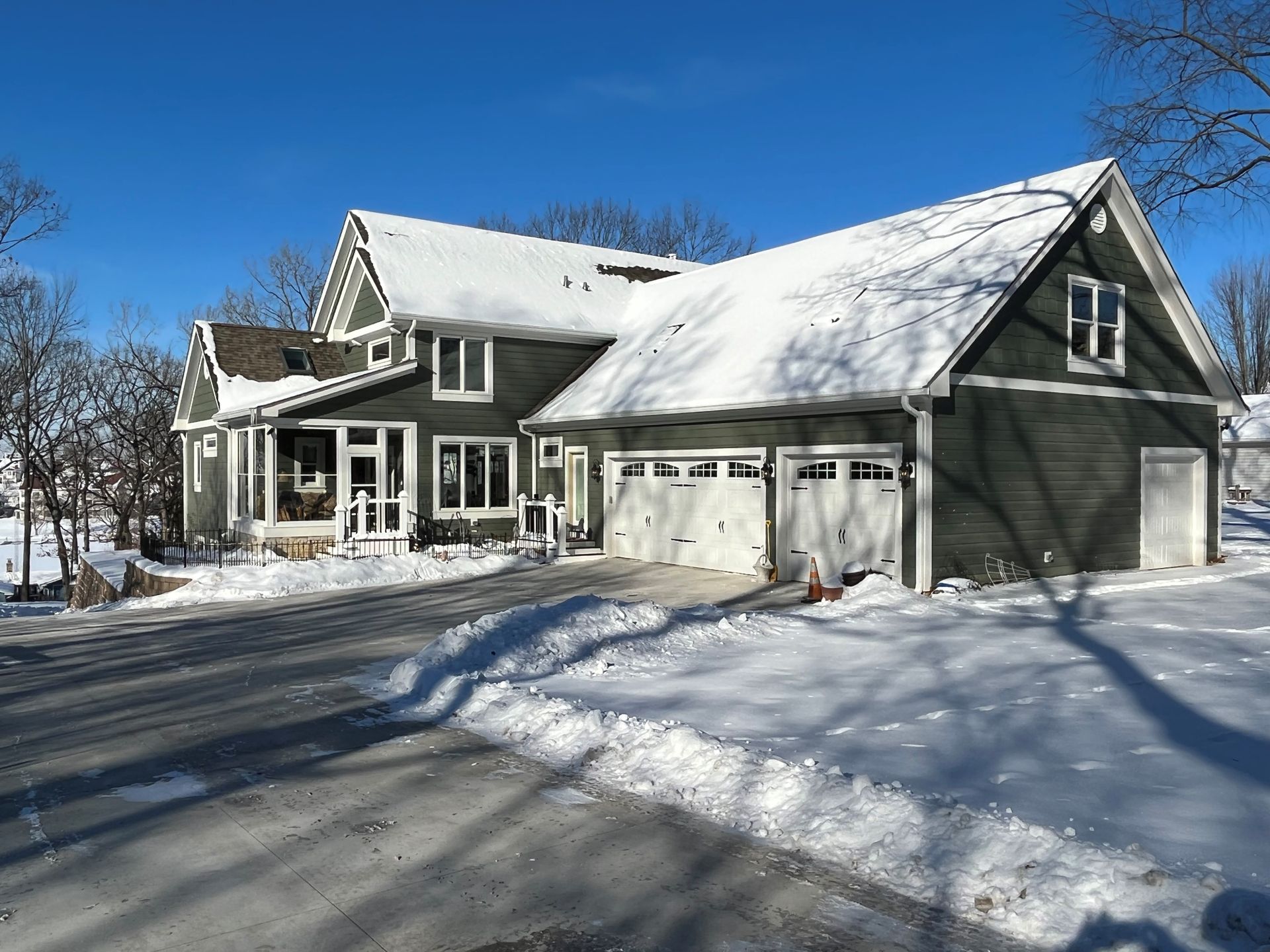 A large house with a garage is covered in snow