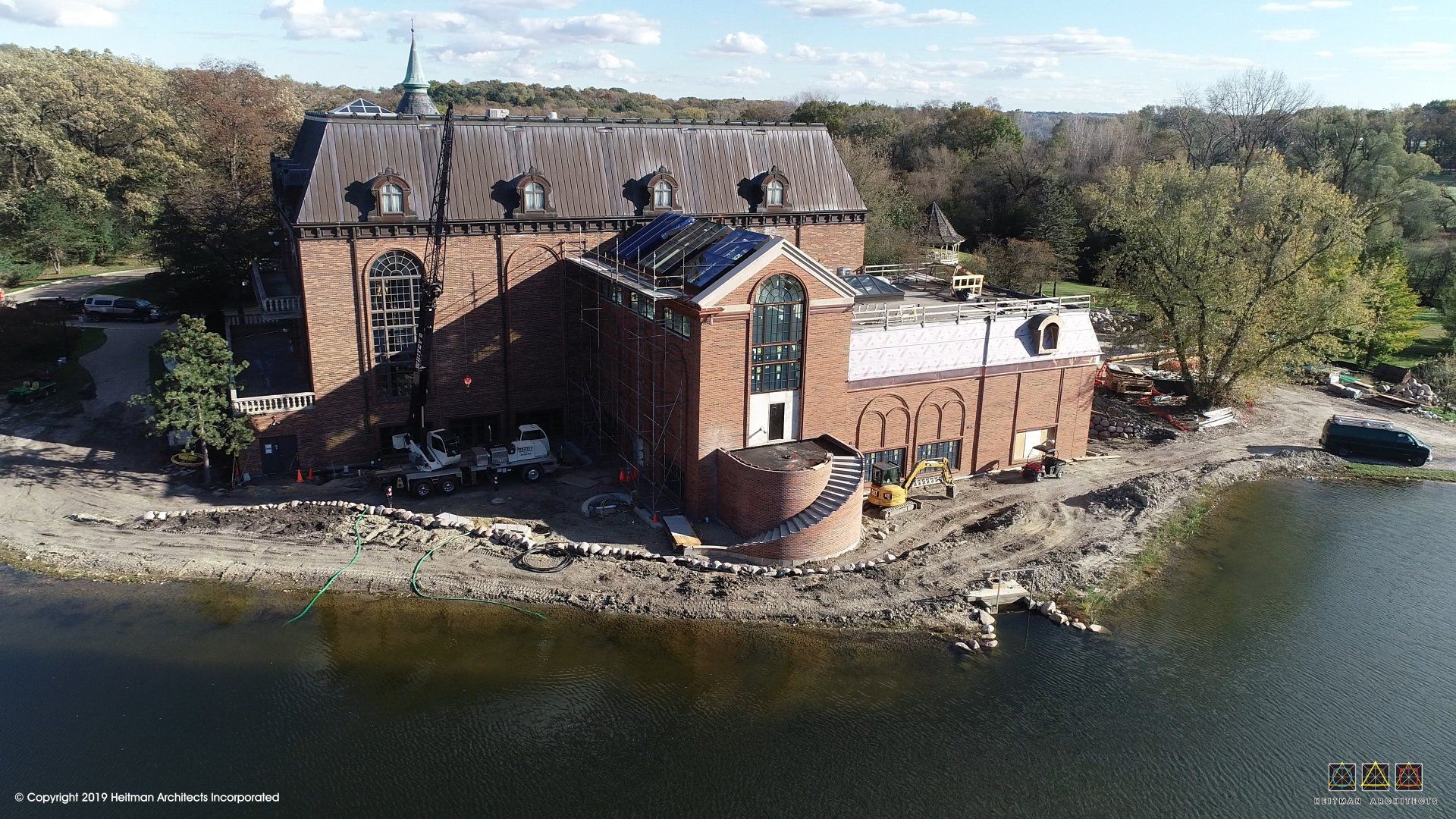 An aerial view of a large brick building next to a body of water.