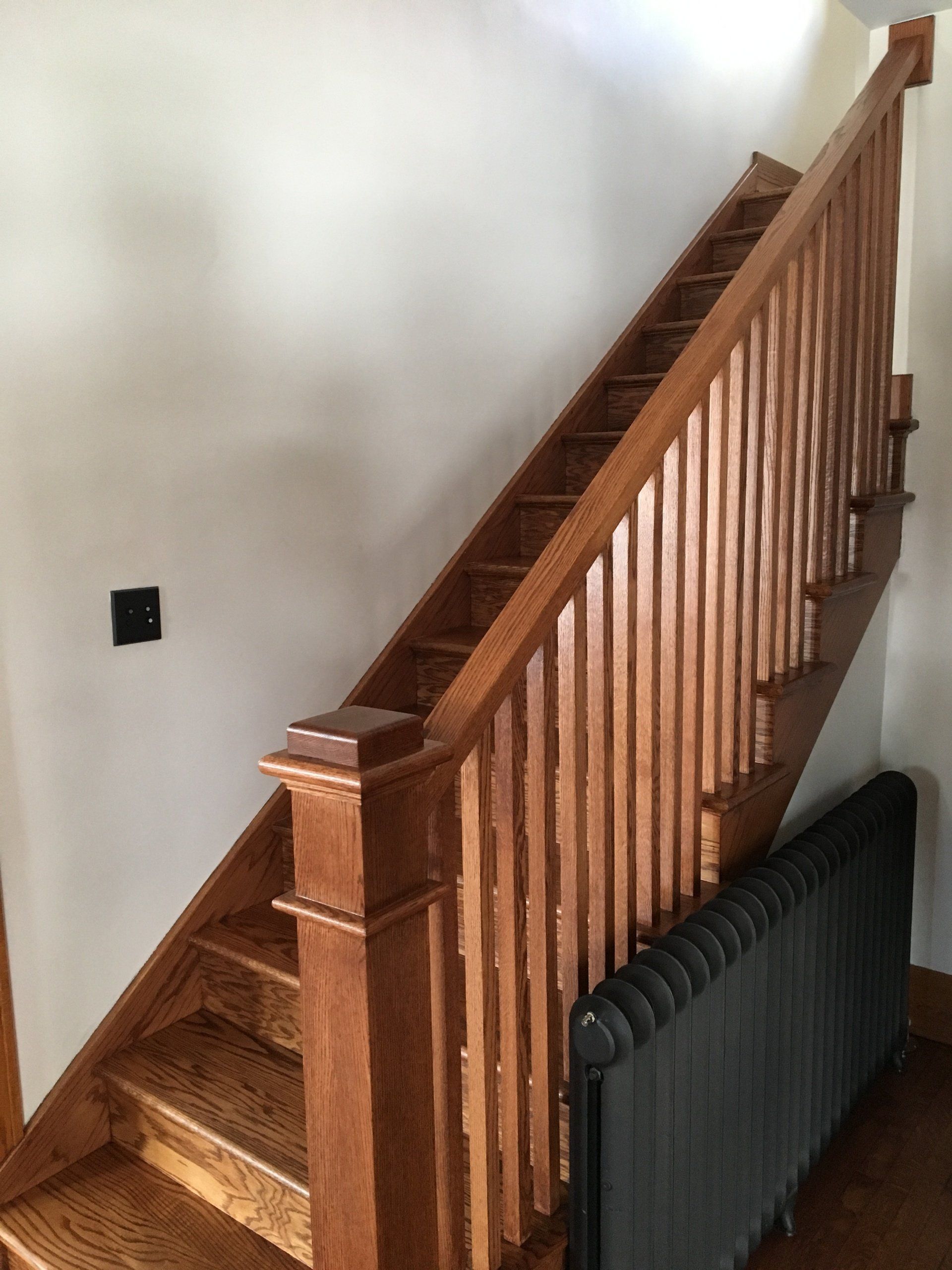 A wooden staircase with a radiator next to it.