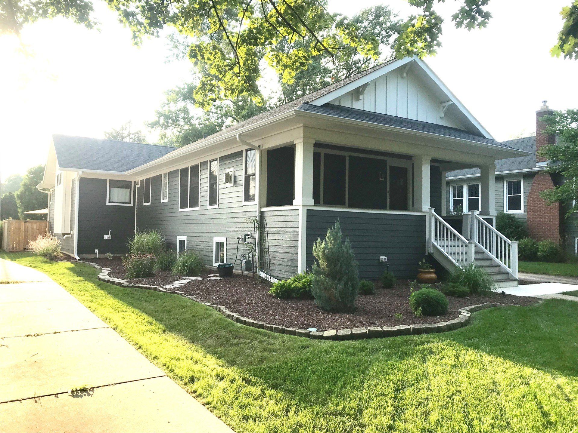 A large house with a screened in porch and stairs.