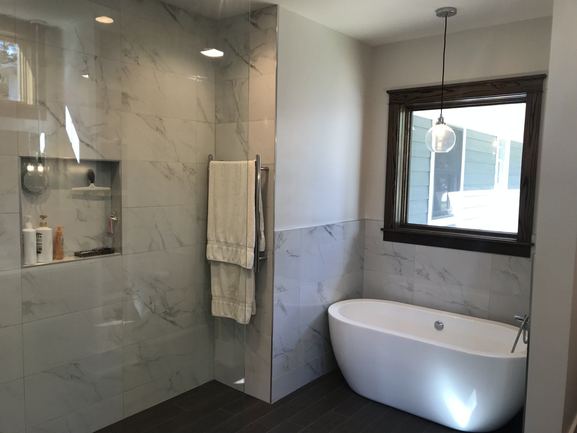 A bathroom with a bathtub , shower , and mirror.