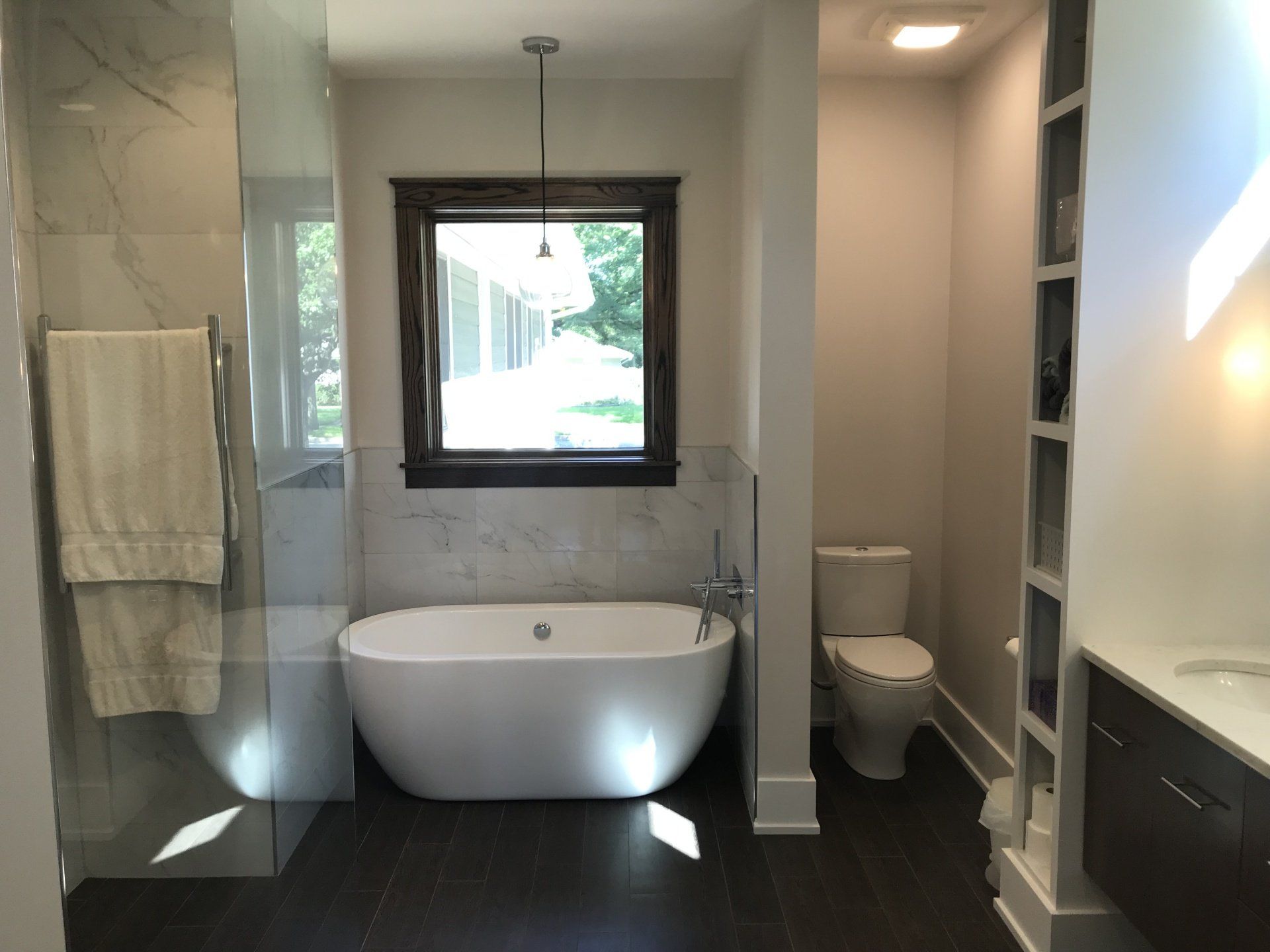 A bathroom with a tub a toilet and a window