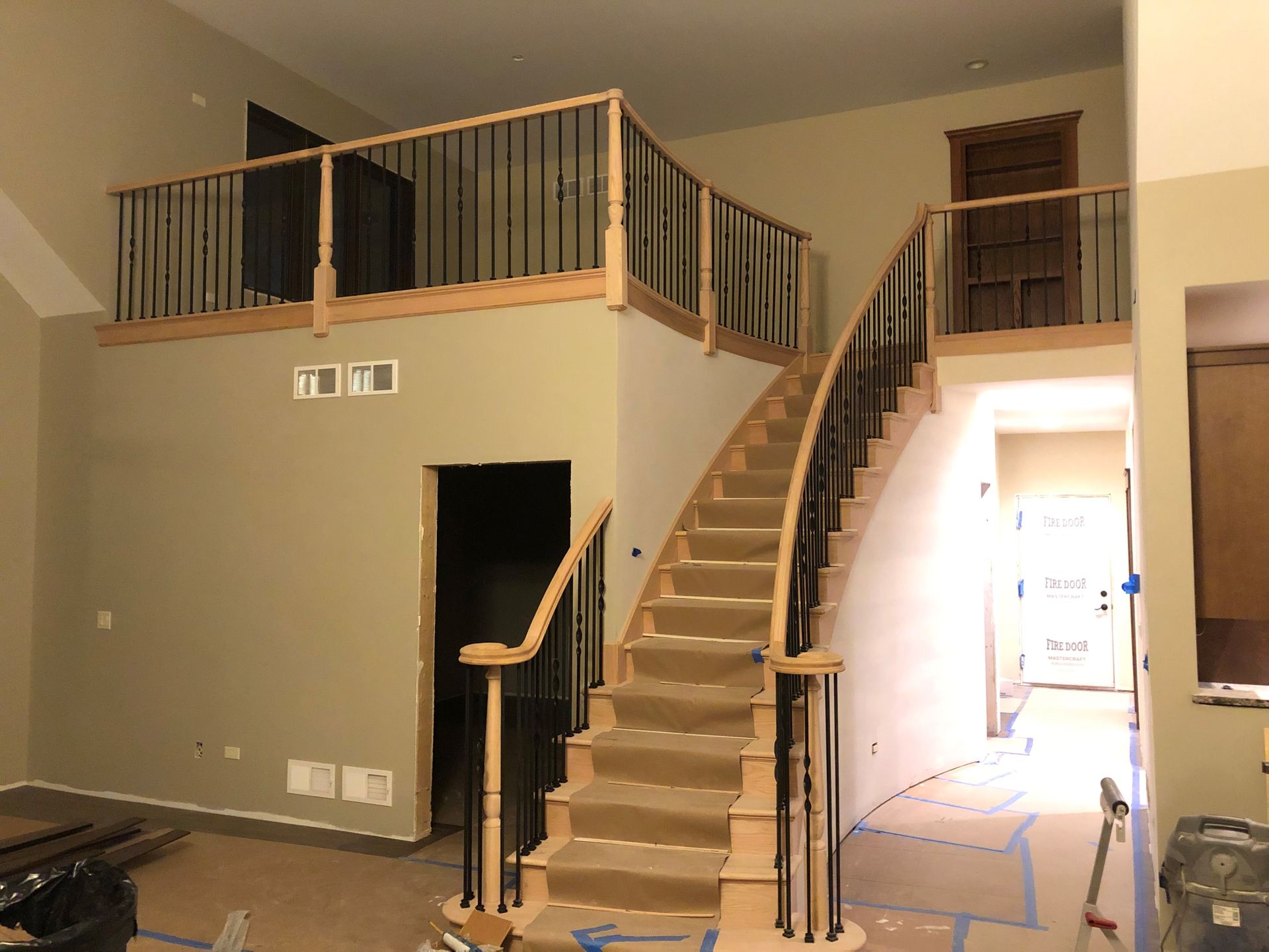 A living room with stairs leading up to a second floor.