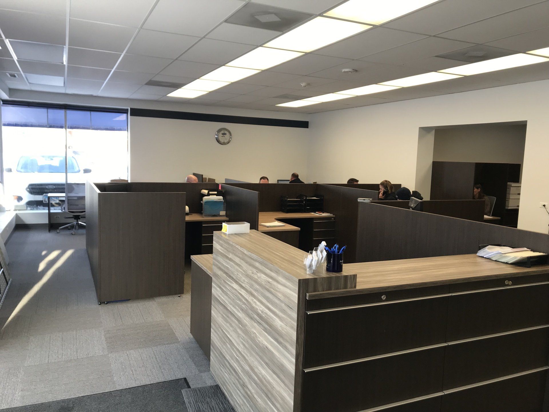 An office with cubicles and a clock on the wall