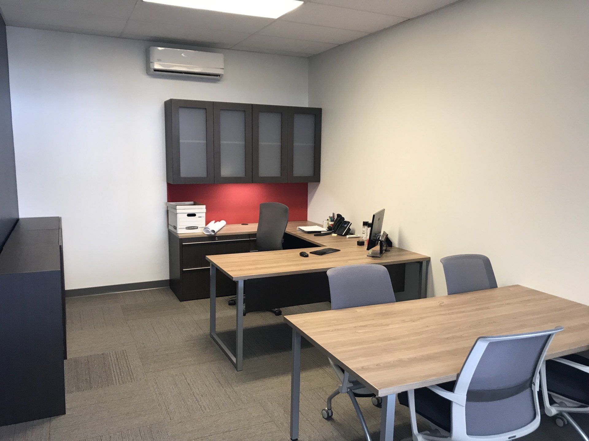 A small office with a desk and chairs