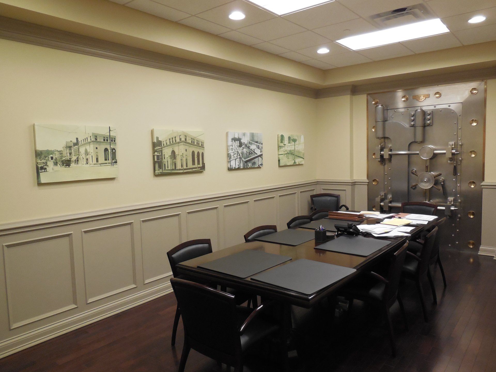A conference room with a table and chairs and paintings on the wall.