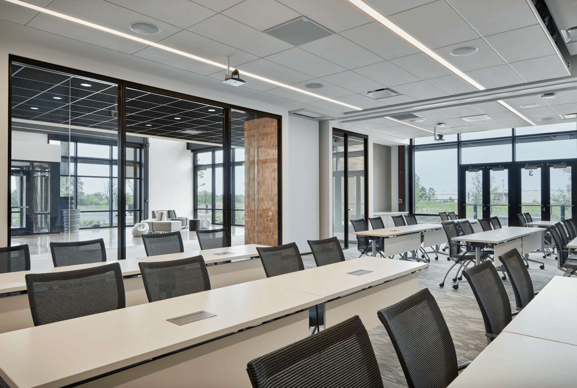 A large conference room with tables and chairs and a lot of windows.