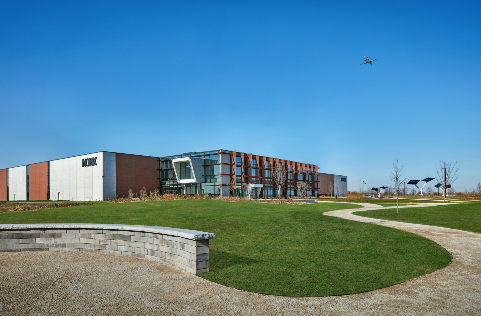 A large building is sitting on top of a lush green field.