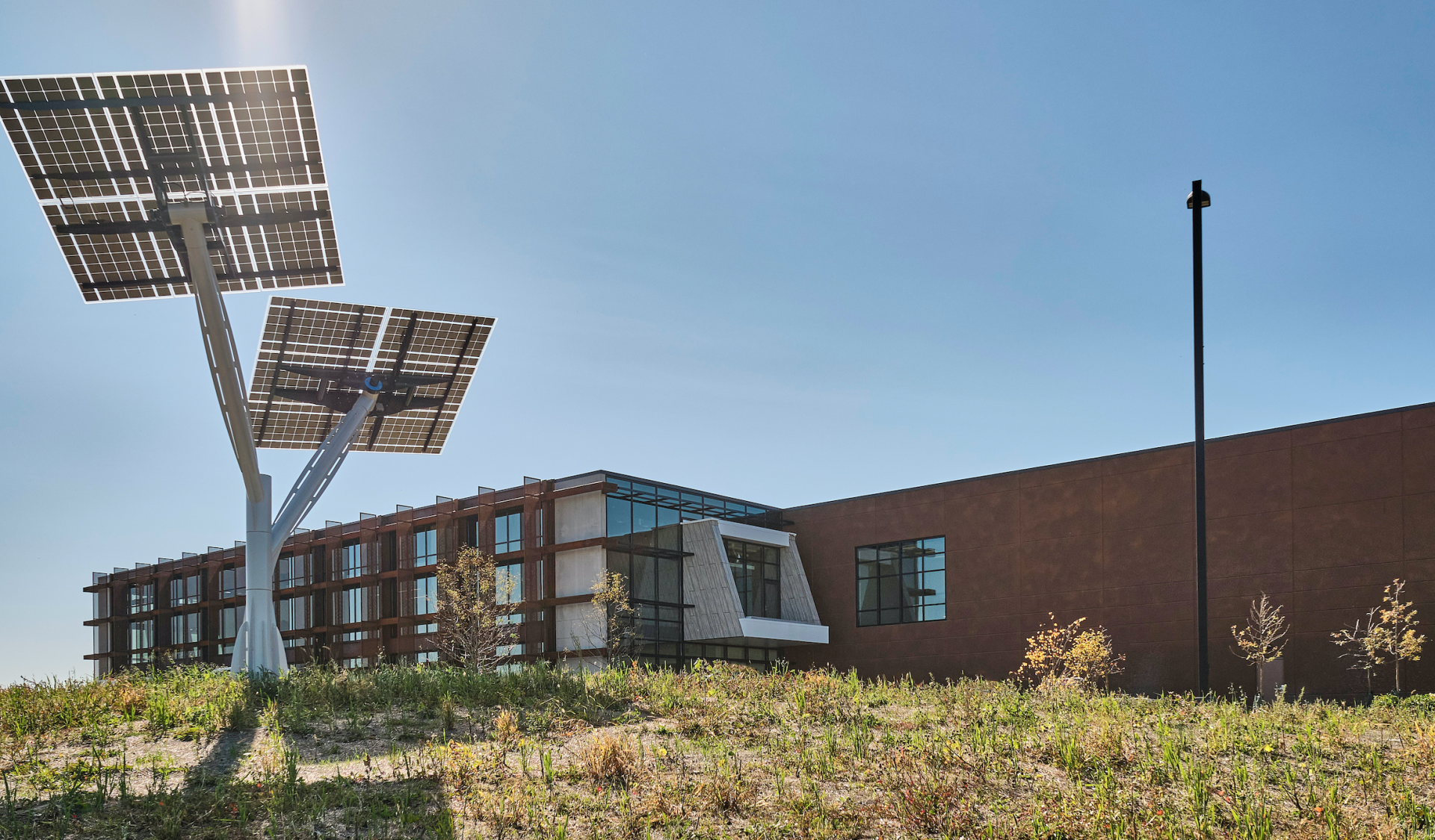 Two solar panels are sitting in front of a building.