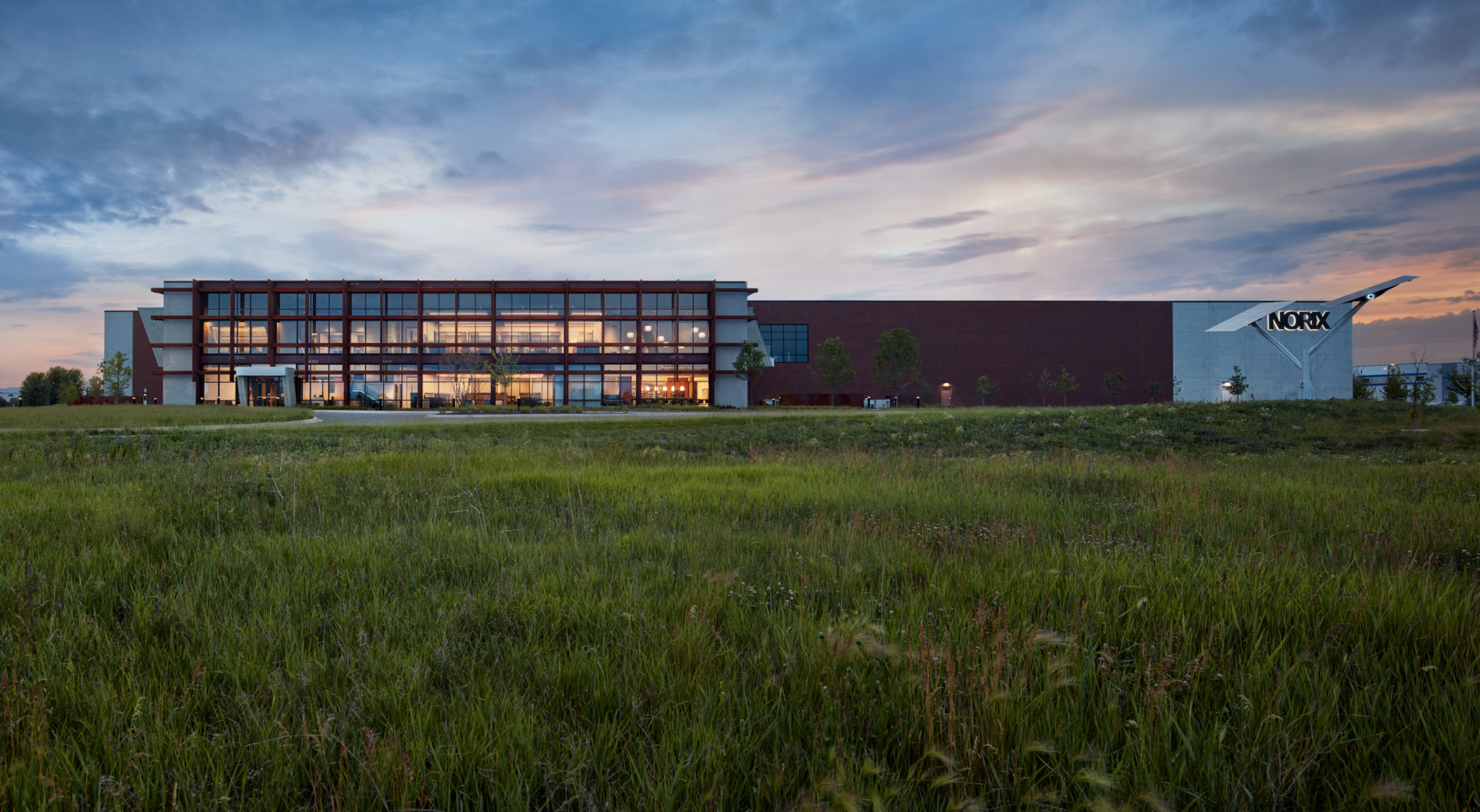 A large building is sitting in the middle of a grassy field.