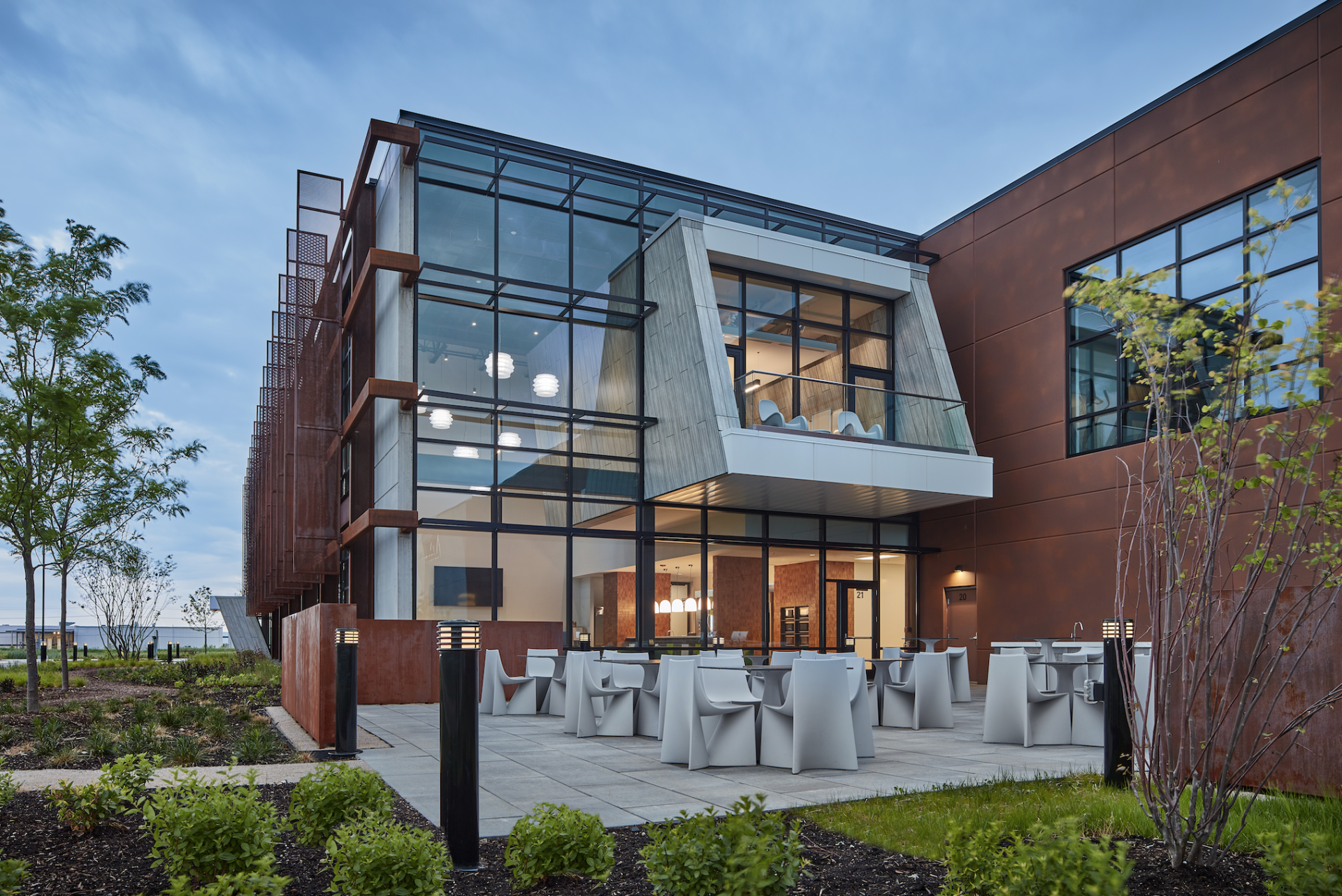 A large building with a lot of windows and tables in front of it.