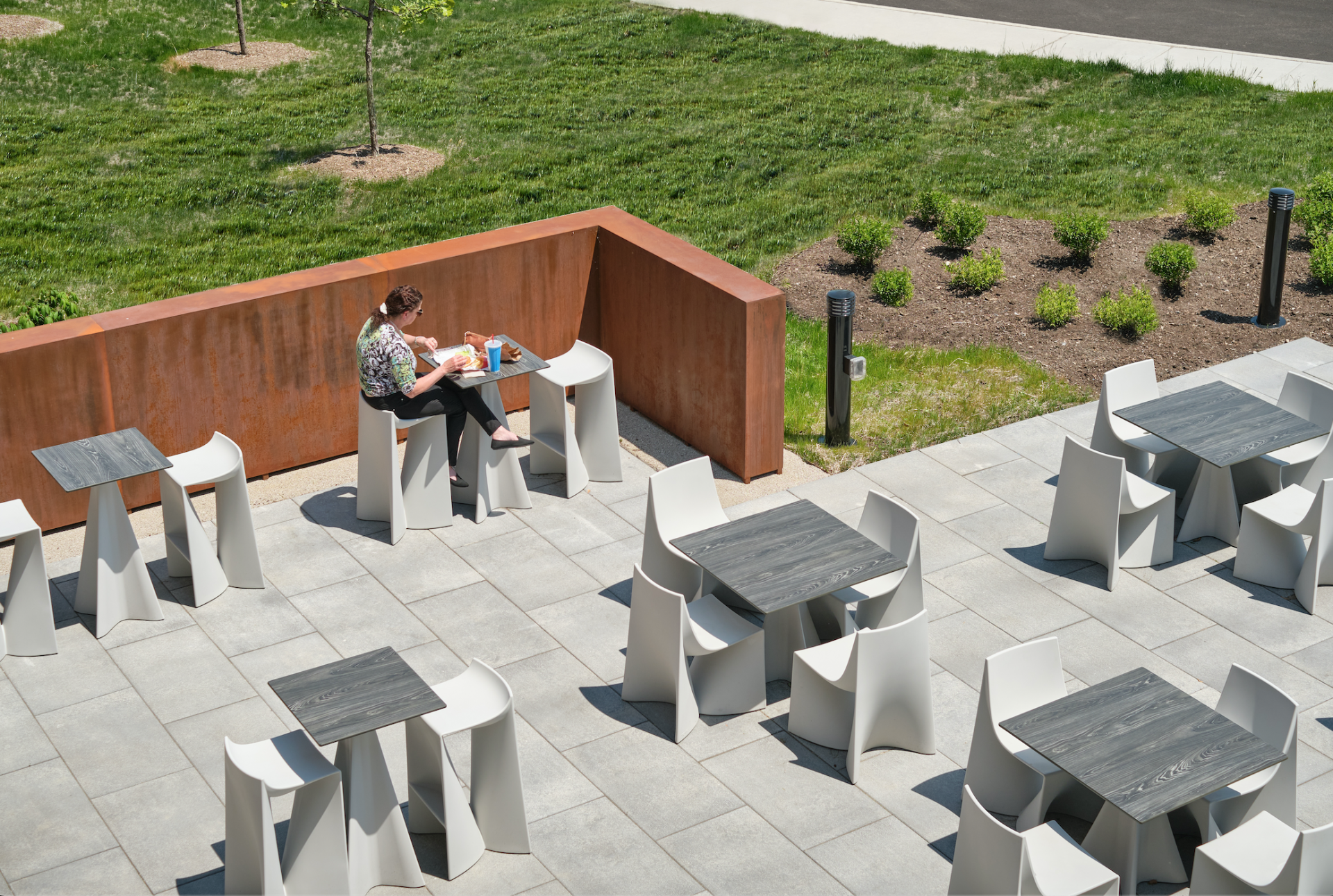 A woman sits at a table surrounded by tables and chairs