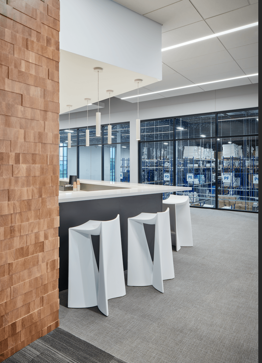A row of white stools are sitting next to a counter in a room.