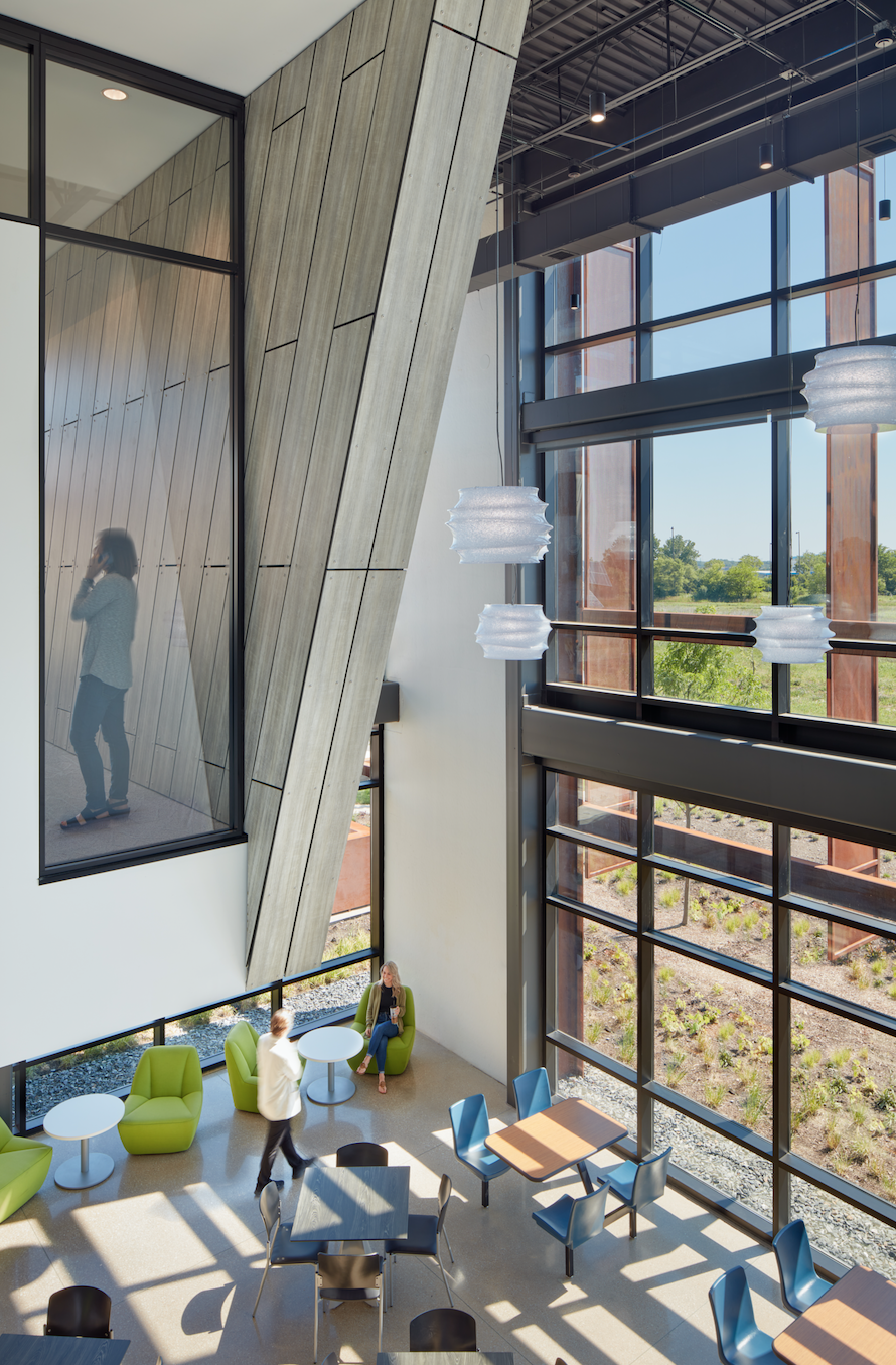 A large building with a lot of windows and tables and chairs