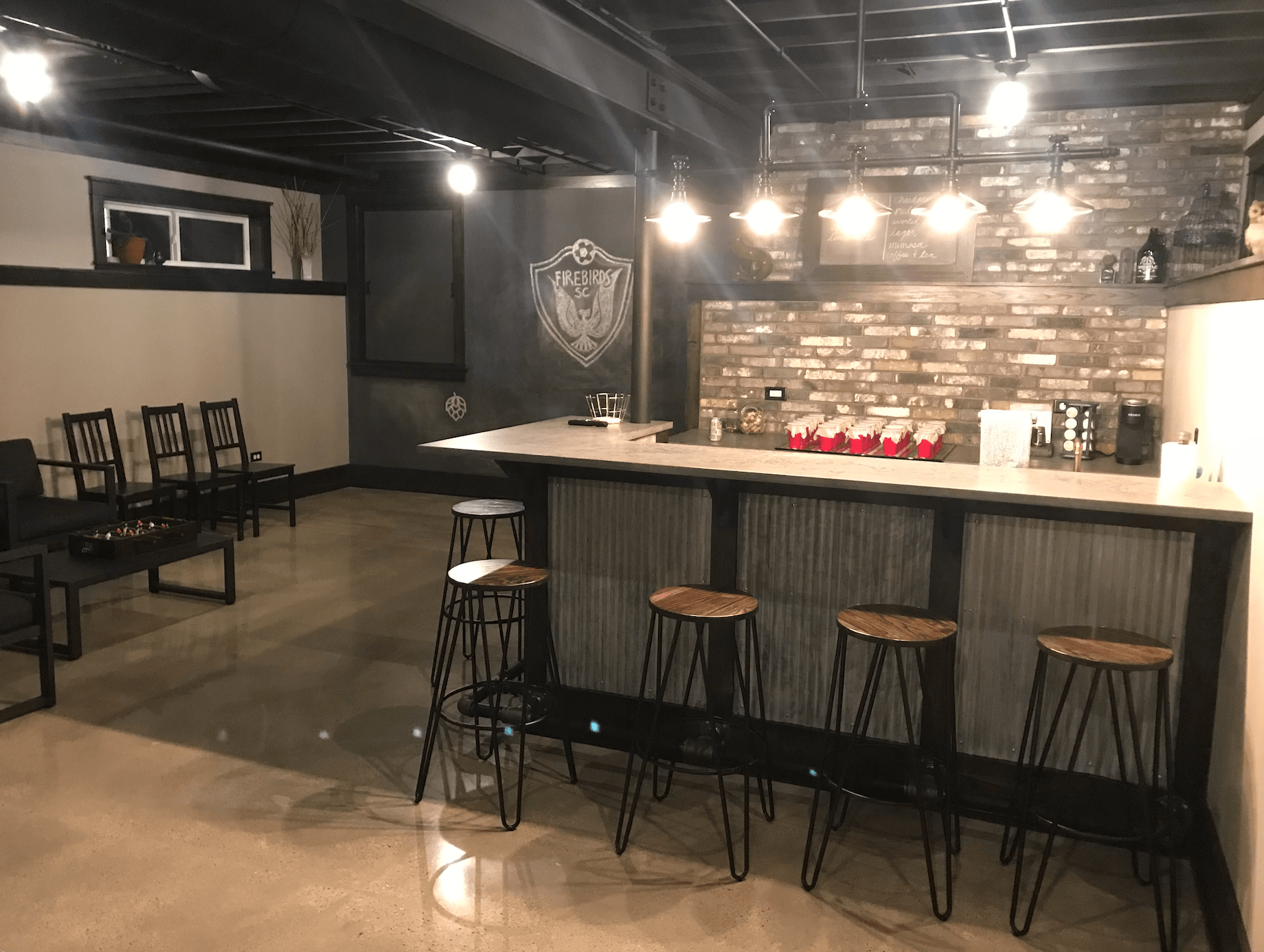 A room with a bar and stools in it.