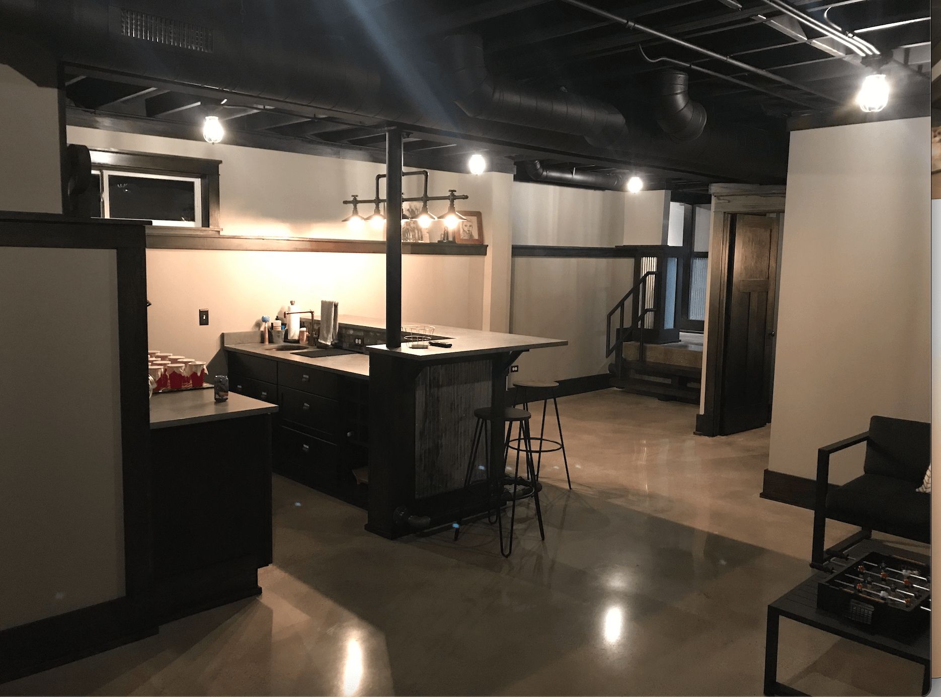 A basement with a bar and stools in it