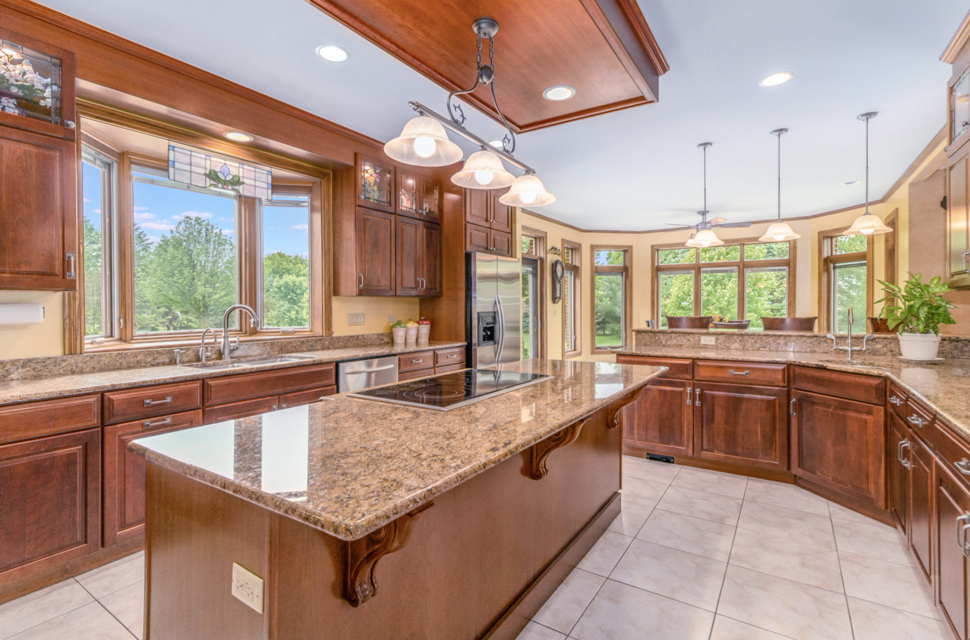 A large kitchen with a large island and granite counter tops.