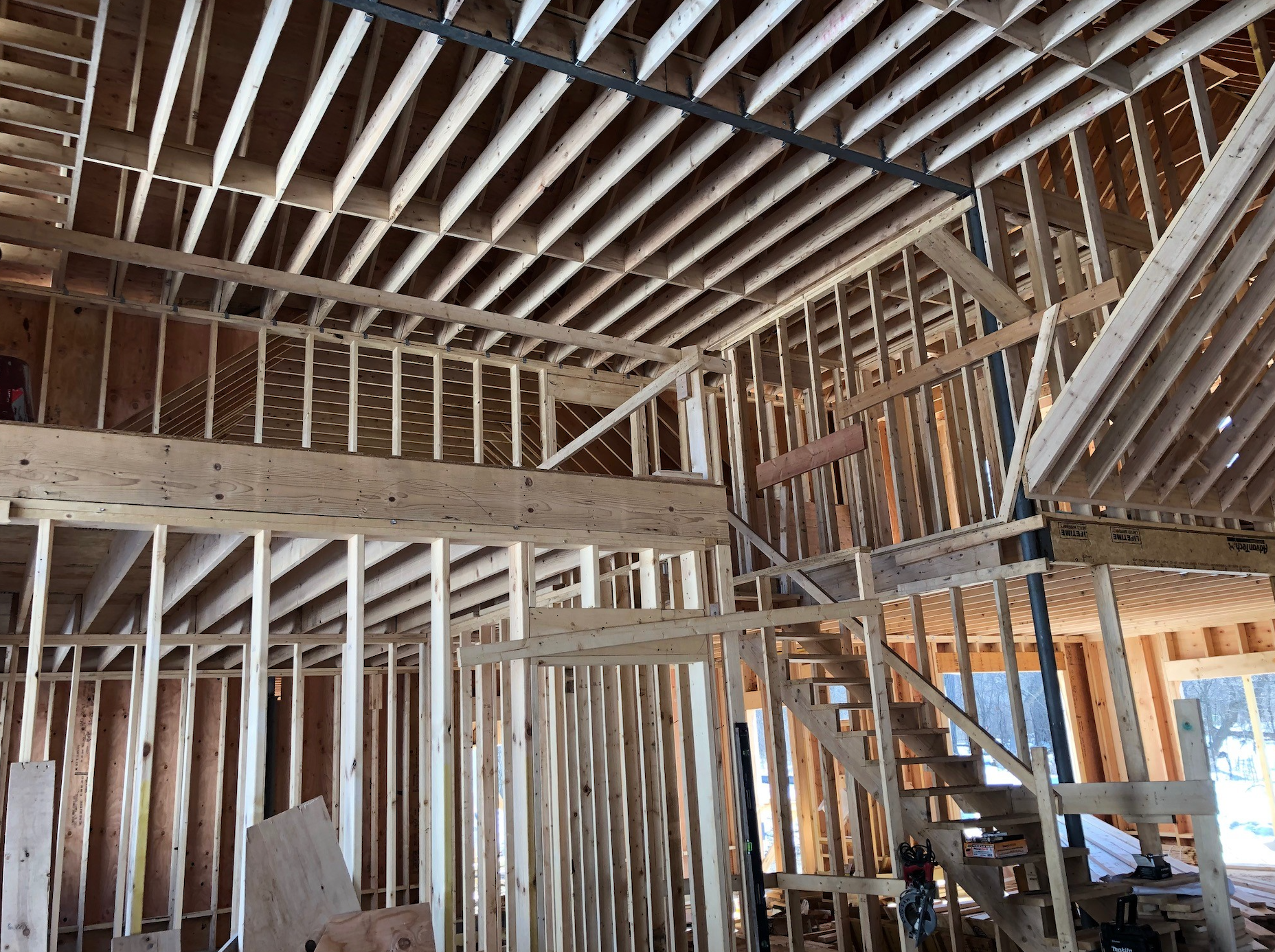 A house is being built with wooden beams and a staircase.