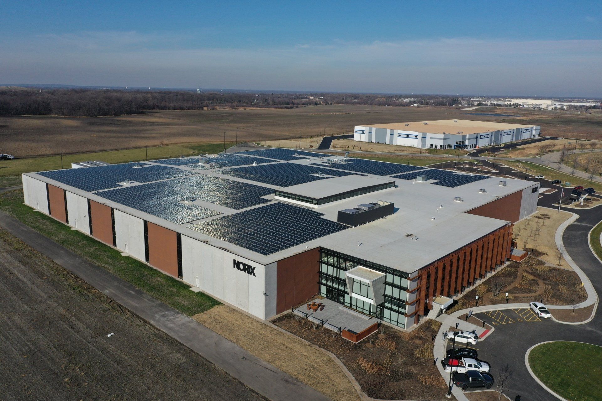 An aerial view of a large building with solar panels on the roof.
