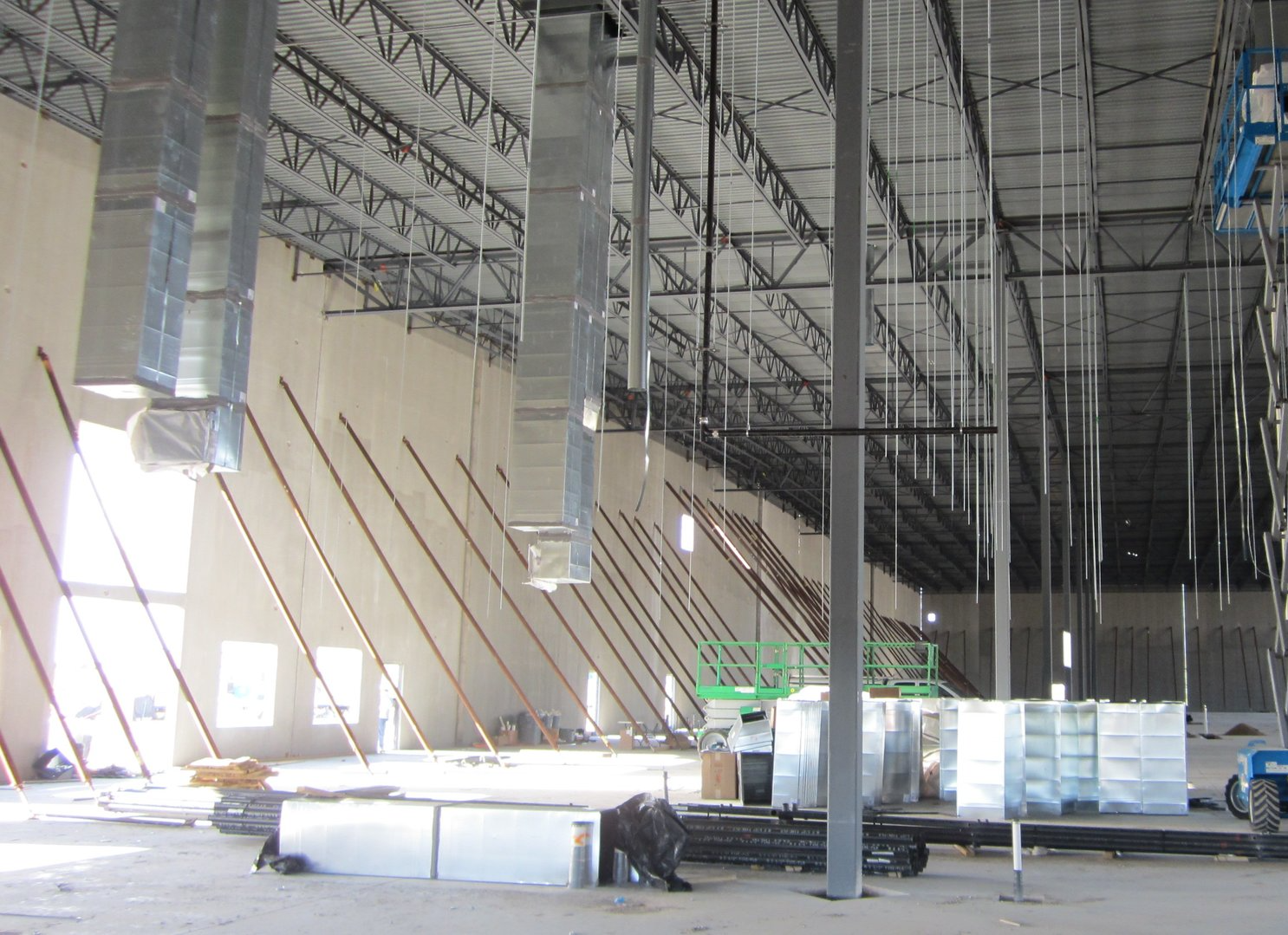 A large building under construction with a lot of pipes hanging from the ceiling