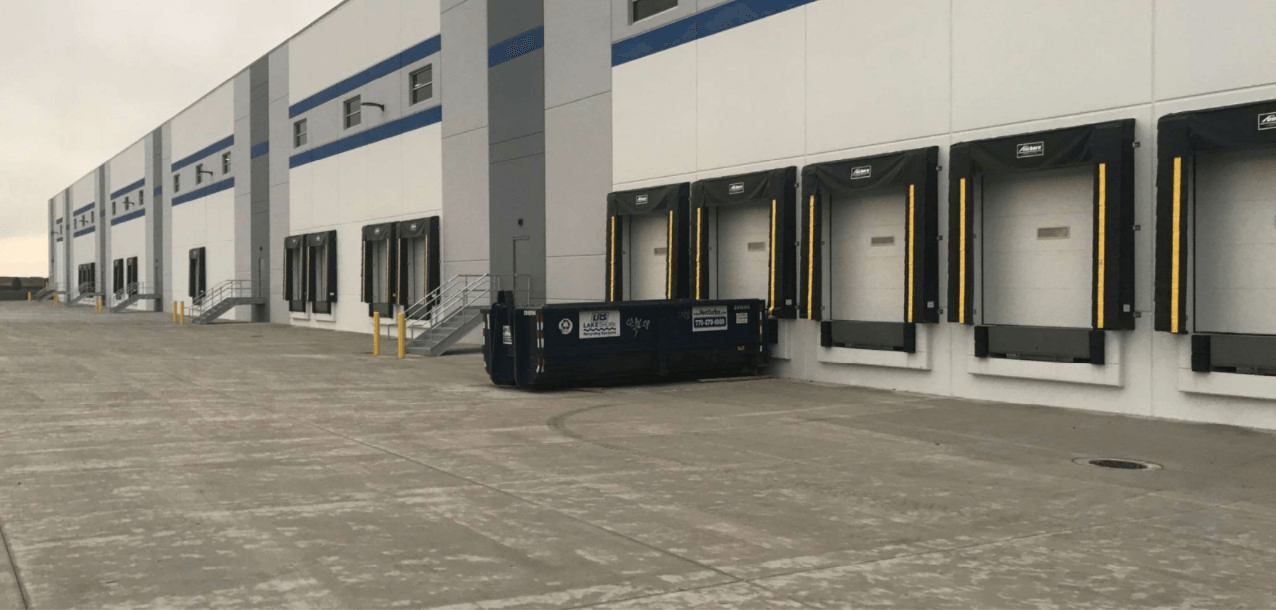 A large warehouse with lots of loading docks on the side of it.