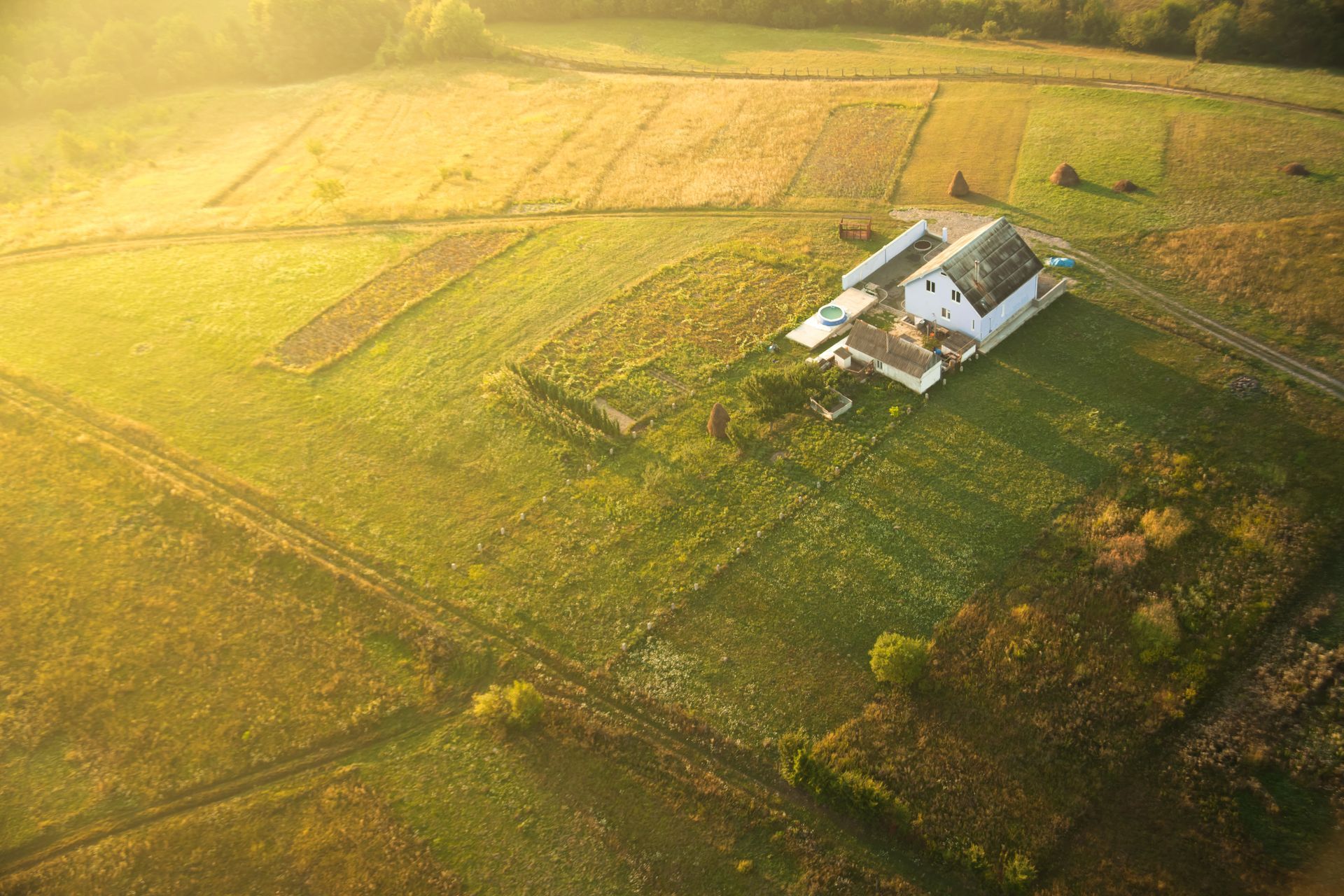 An aerial view of a house in the middle of a field.