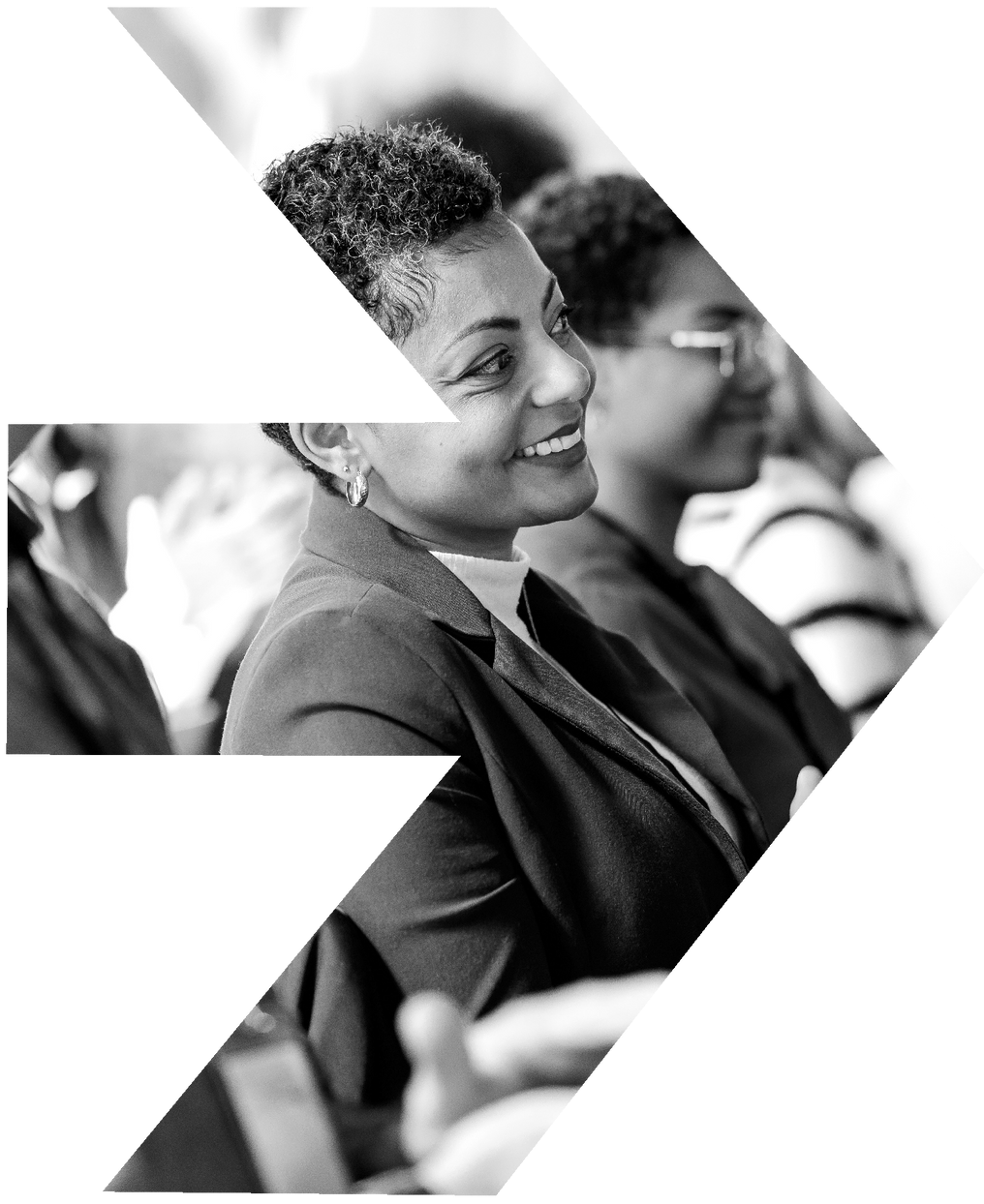 A woman in a suit is smiling in a black and white photo
