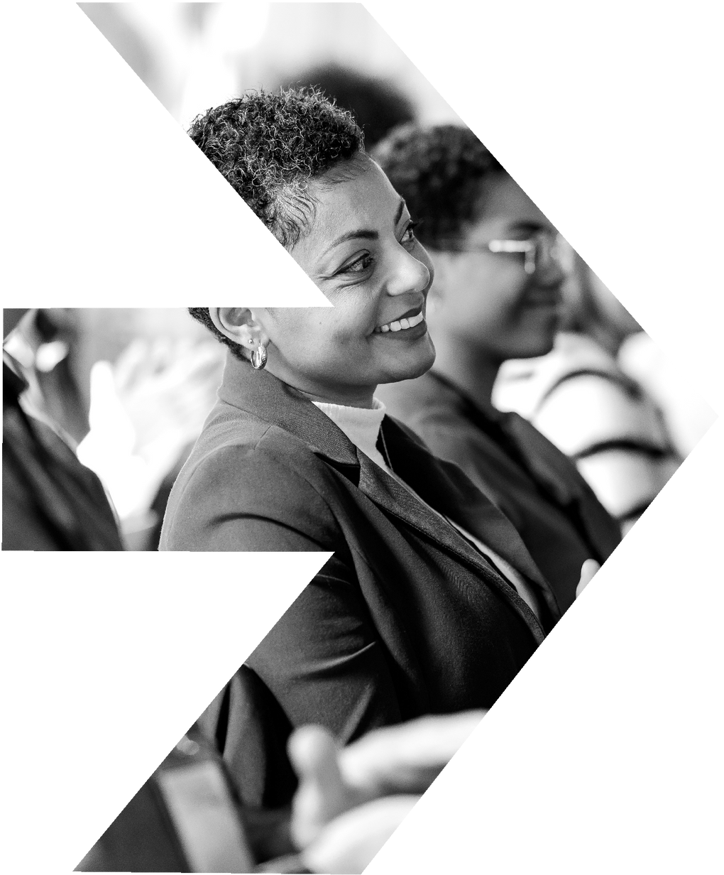 A woman in a suit is smiling in a black and white photo