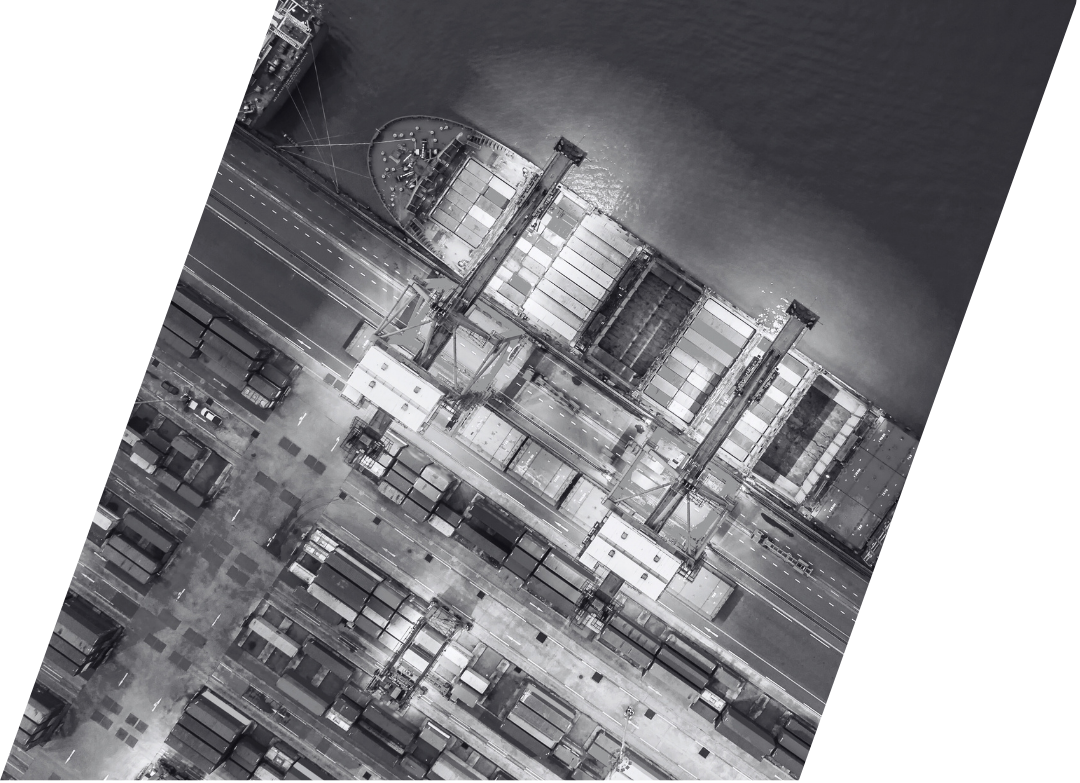A black and white photo of a shipping carrier and containers at a port