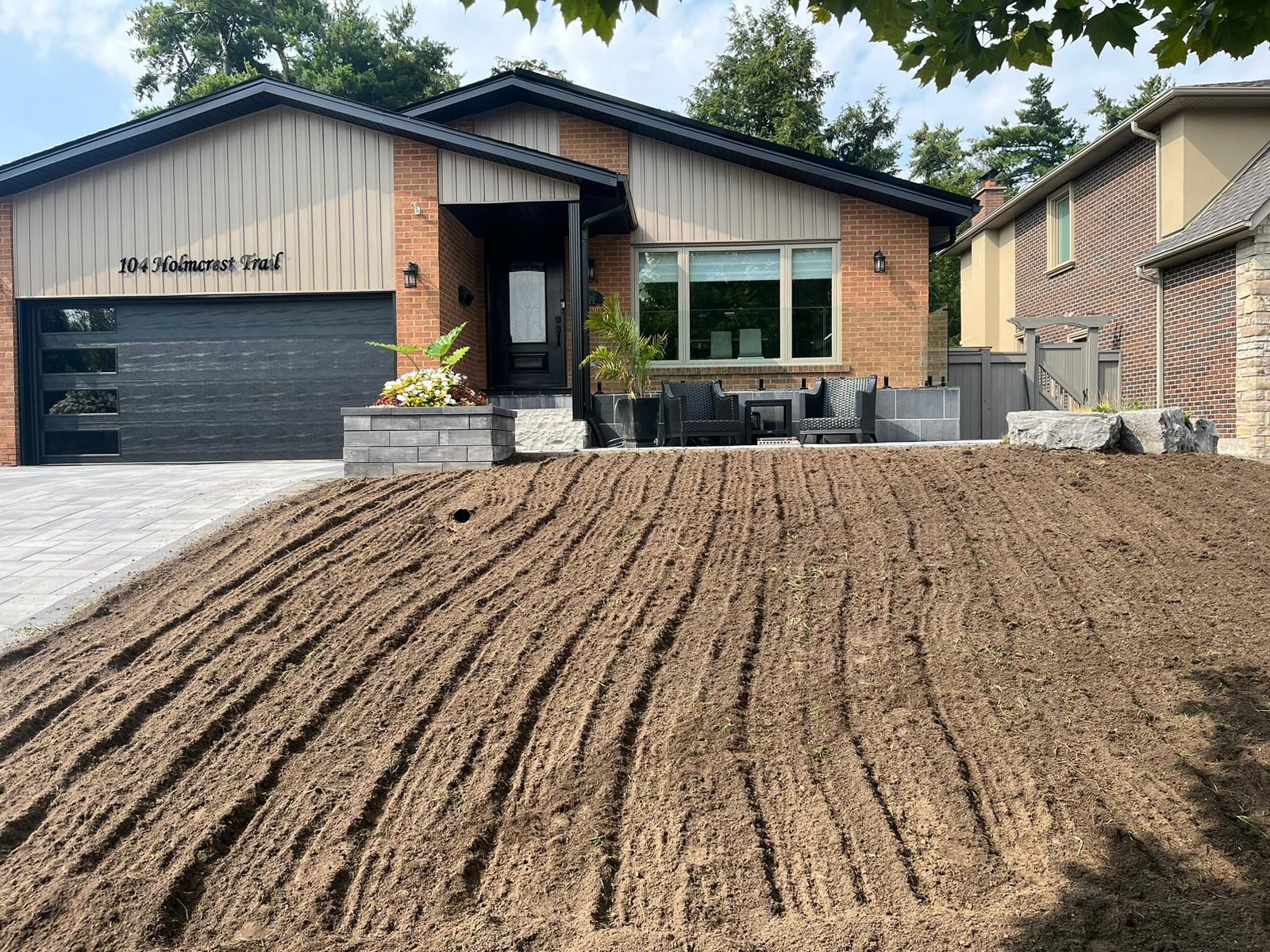 A front lawn with new soil before new sod is installed.