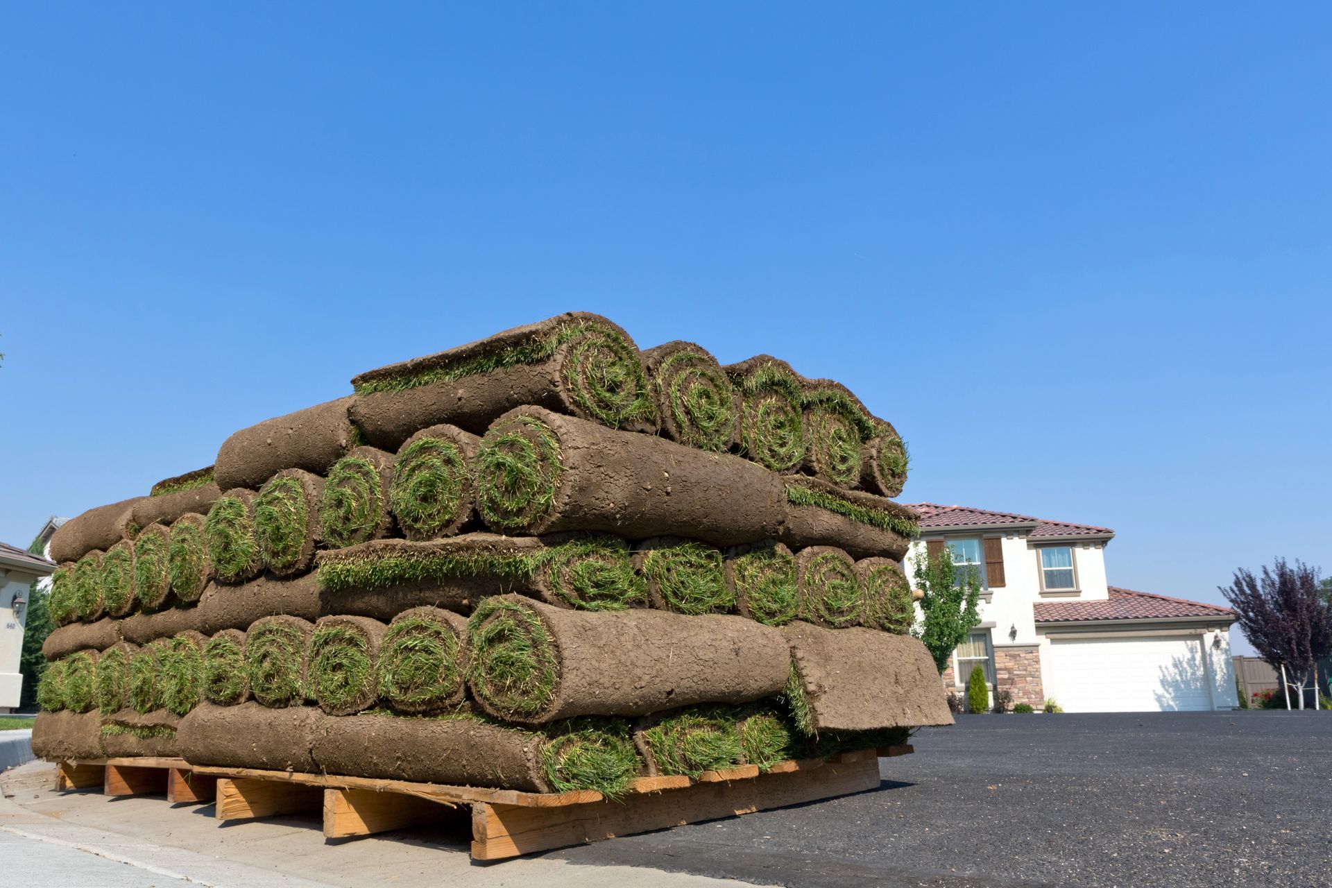 A skid roll of artificial grass is laying on the ground.
