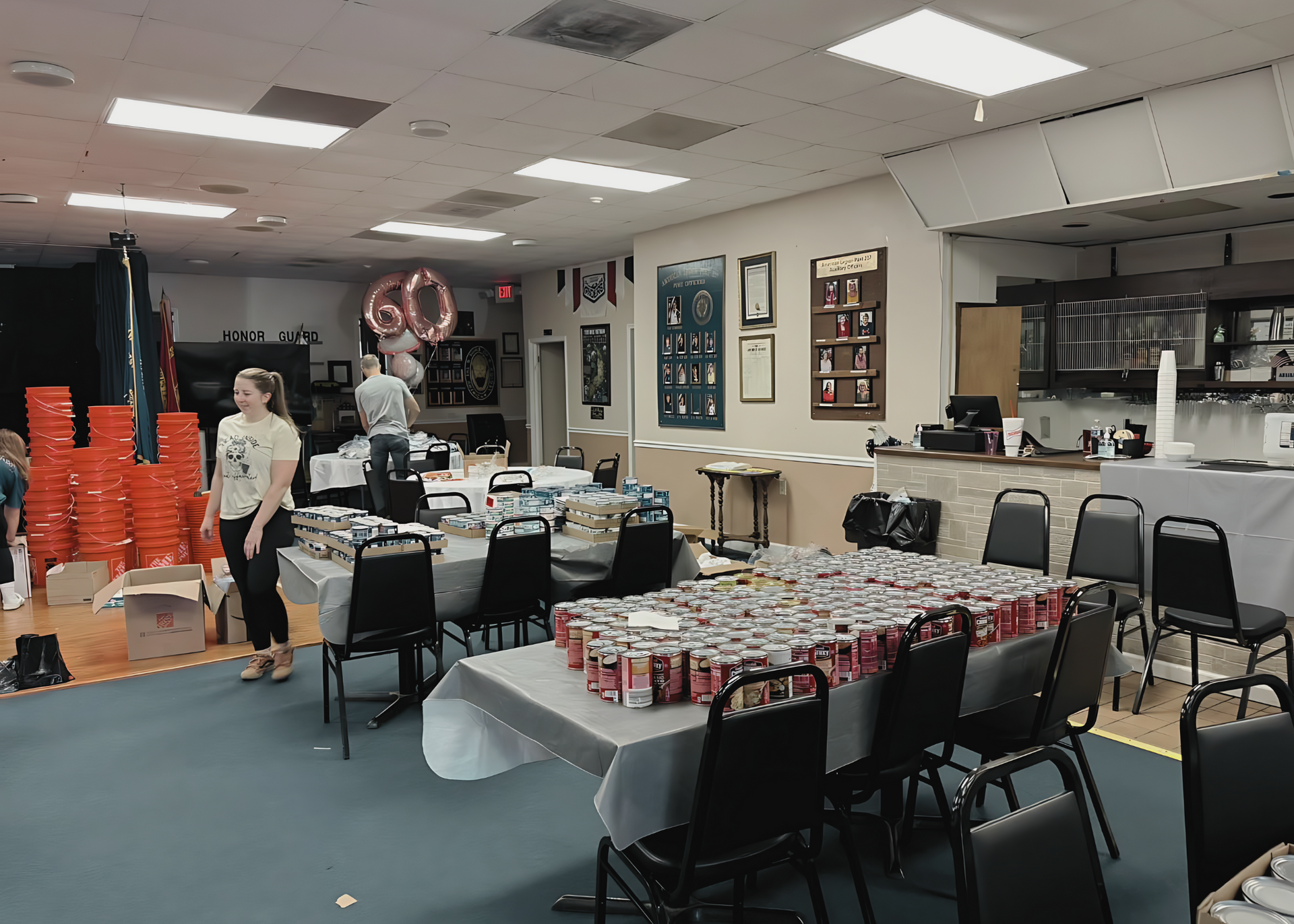 A large room with tables and chairs and a sign that says 60