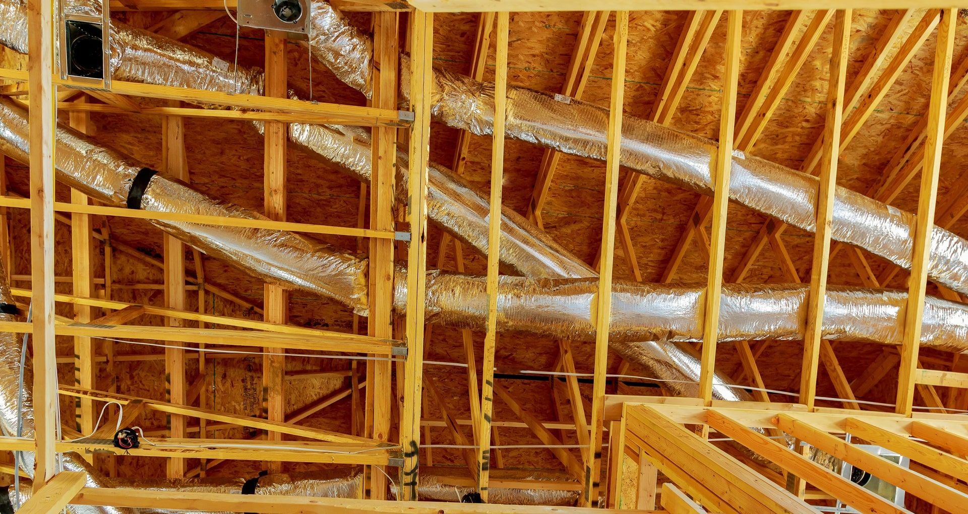 The ceiling of a building under construction with a lot of pipes coming out of it.