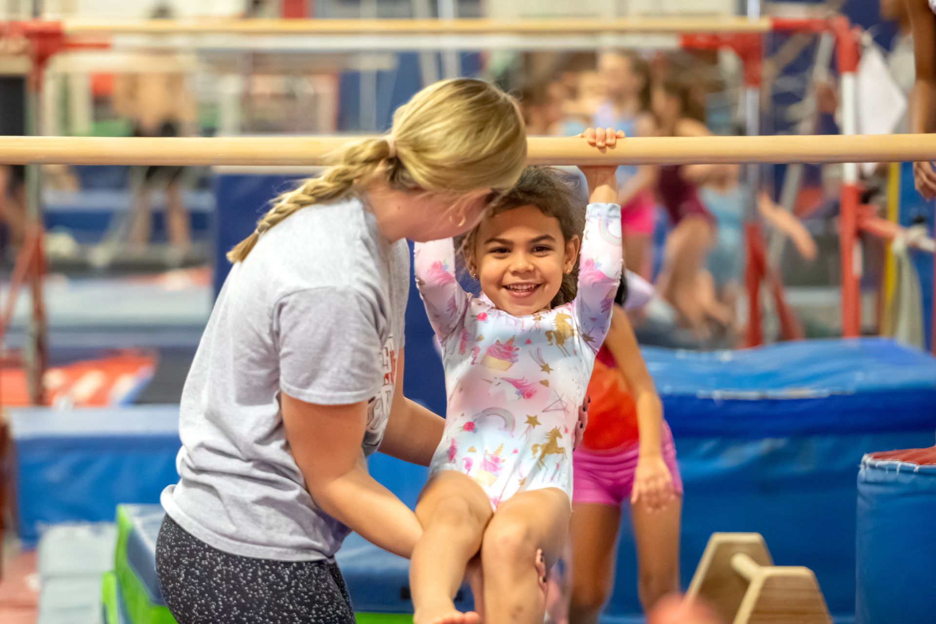 A young girl is doing a handstand on a blue mat