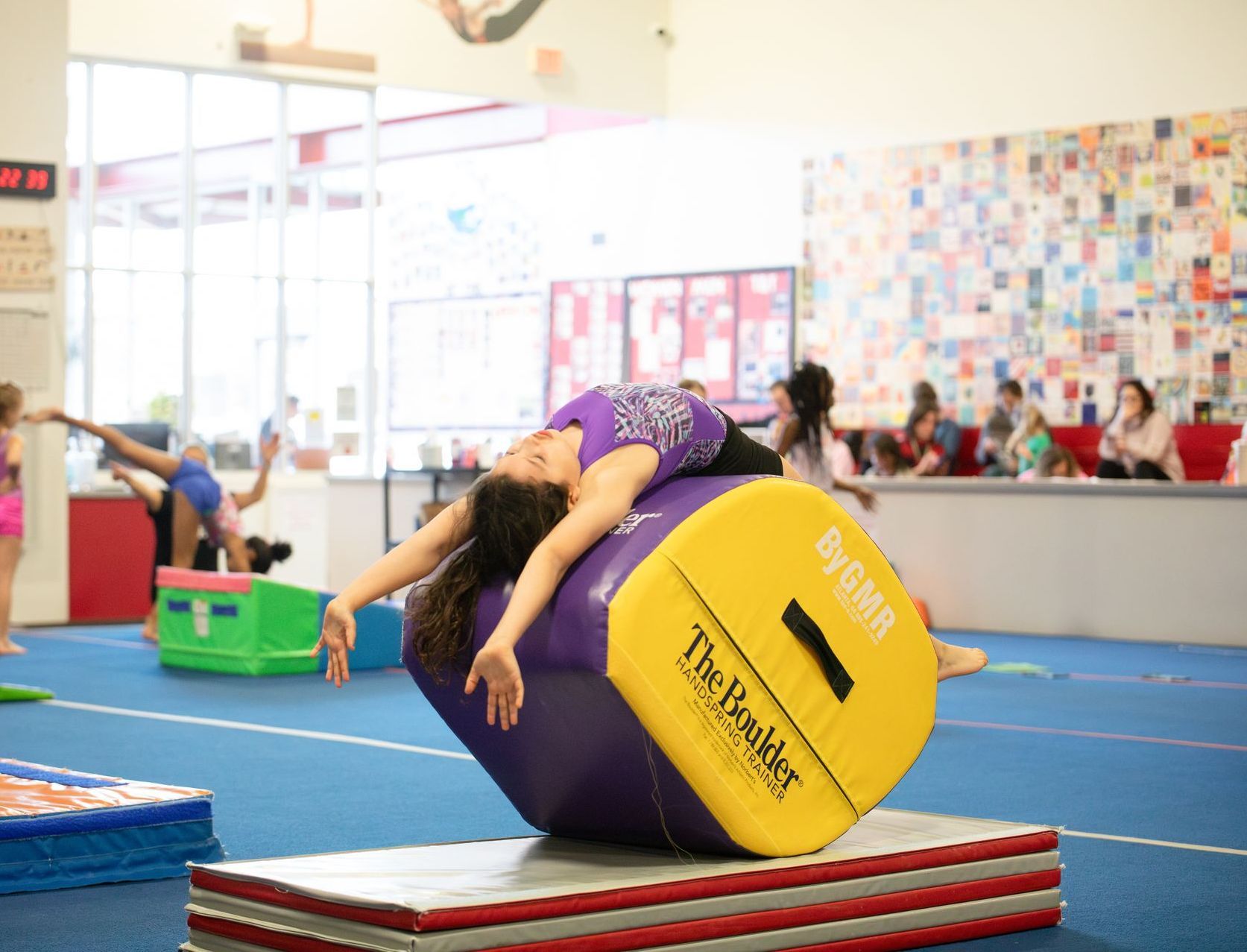 A female gymnast is doing a handstand in a gym.