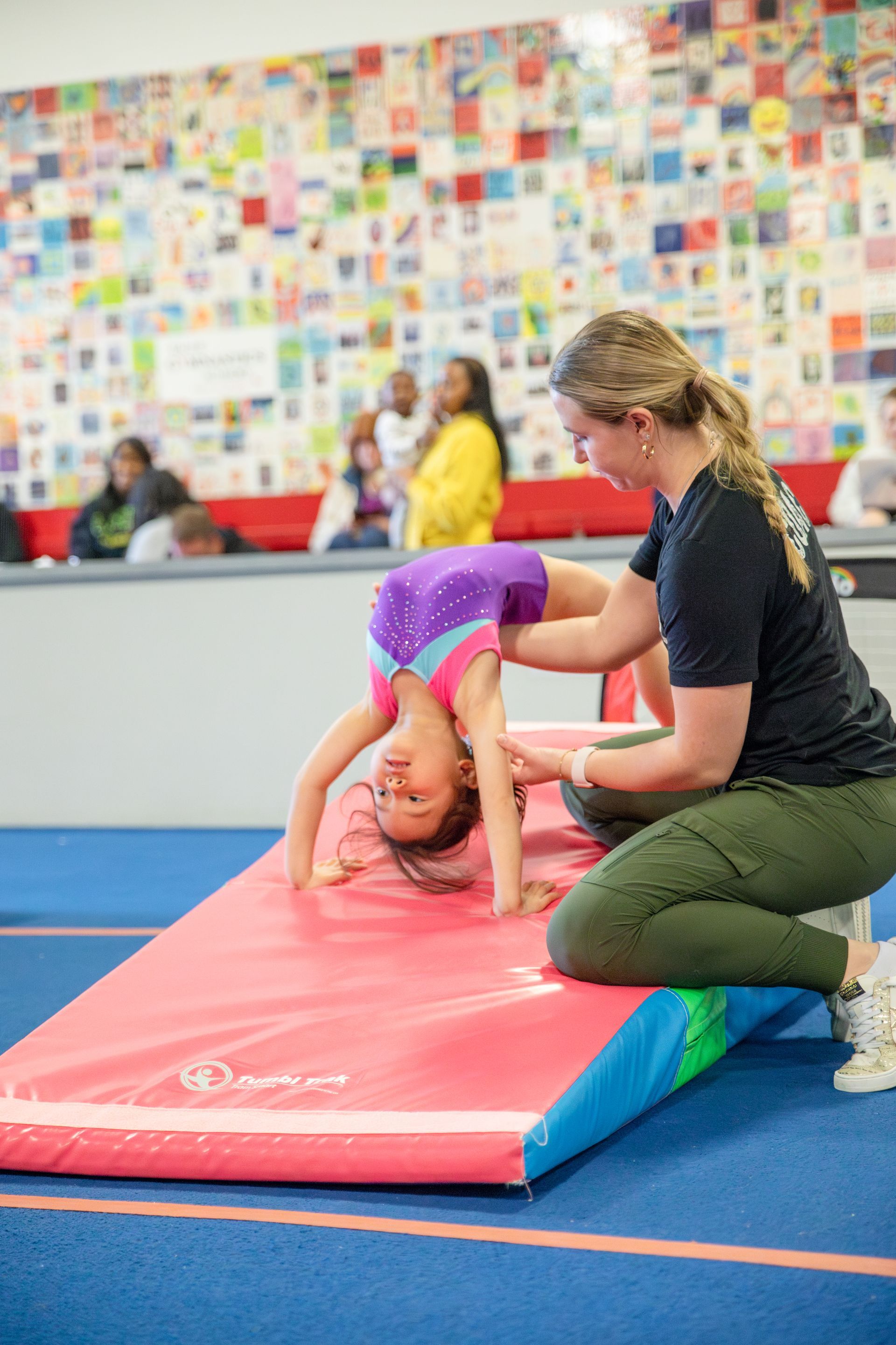 A young boy is doing a handstand on a trampoline.