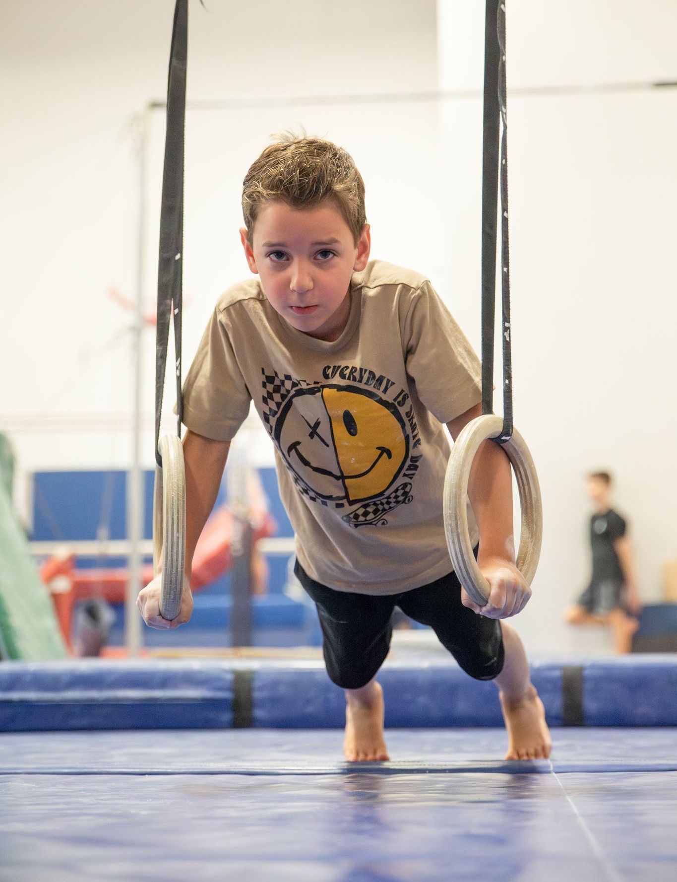 A young boy wearing a marvel shirt is laying on the floor