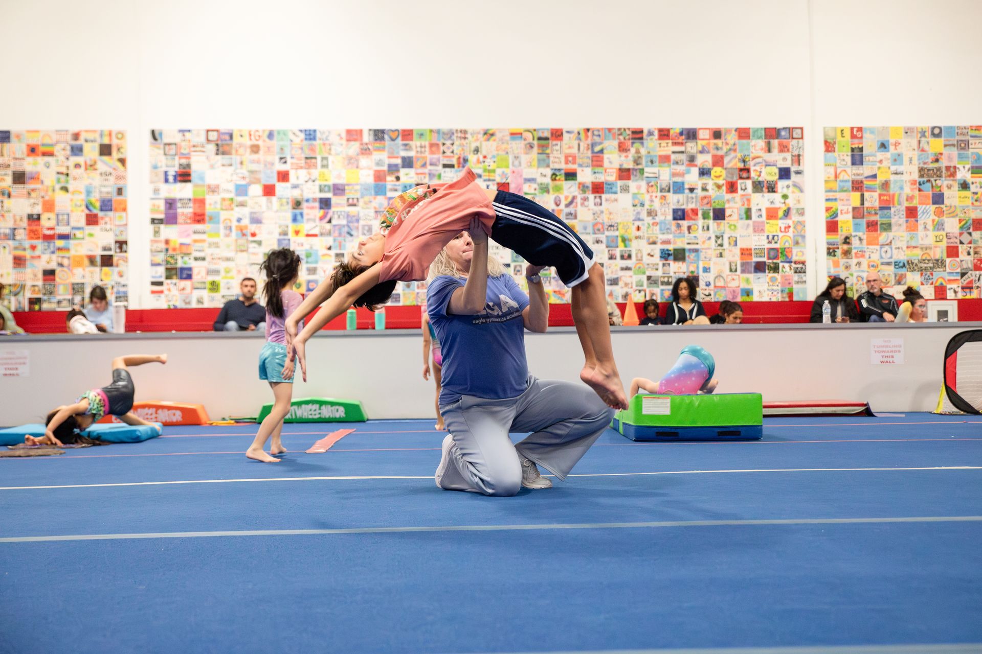 A female gymnast is doing a trick on a trampoline.