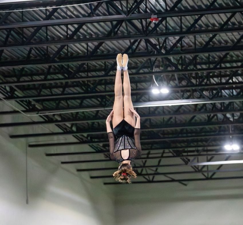 A woman is doing a handstand in the air