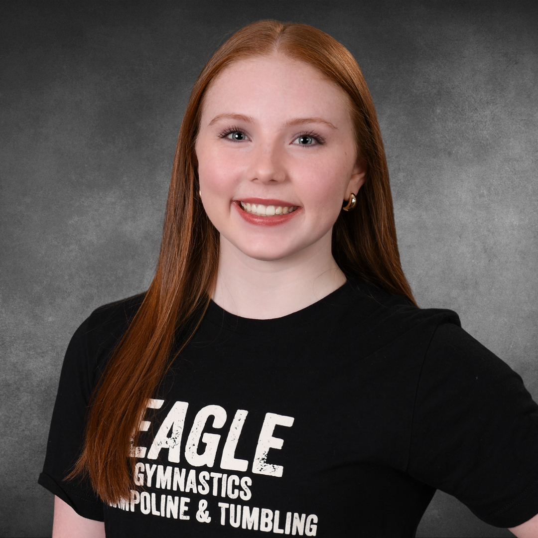 A girl with red hair is wearing an eagle gymnastics t-shirt