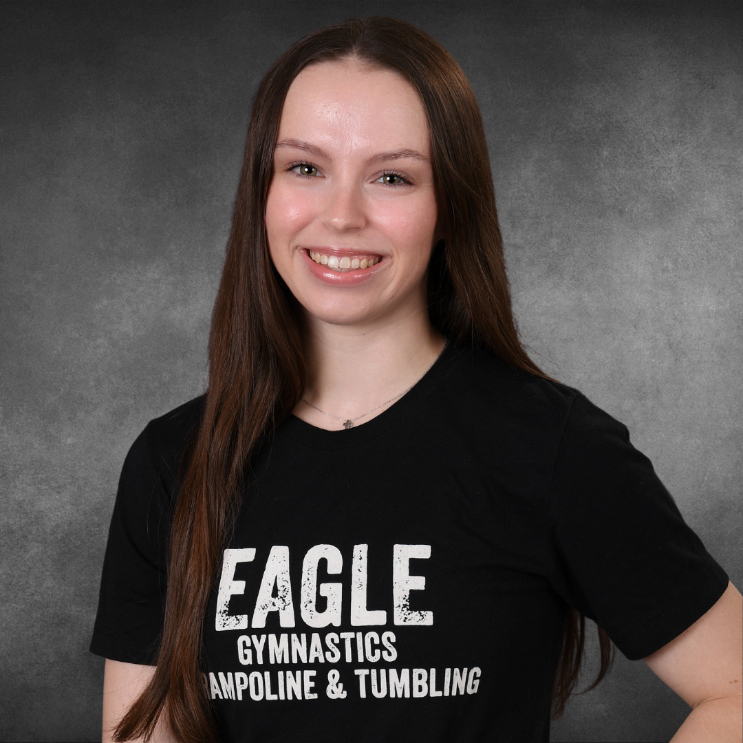 A woman wearing a black eagle gymnastics t-shirt