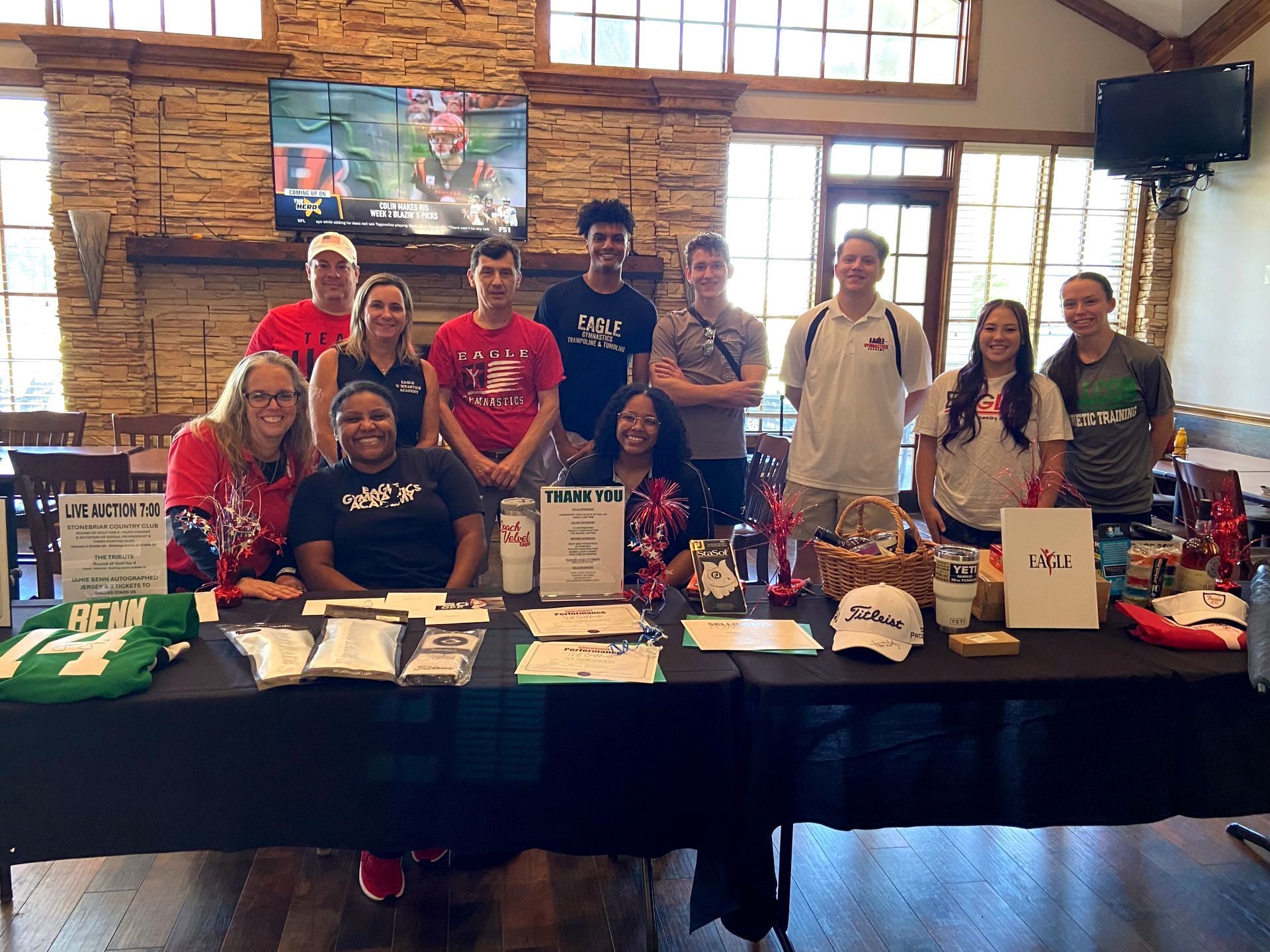 A group of people are posing for a picture in front of a table.