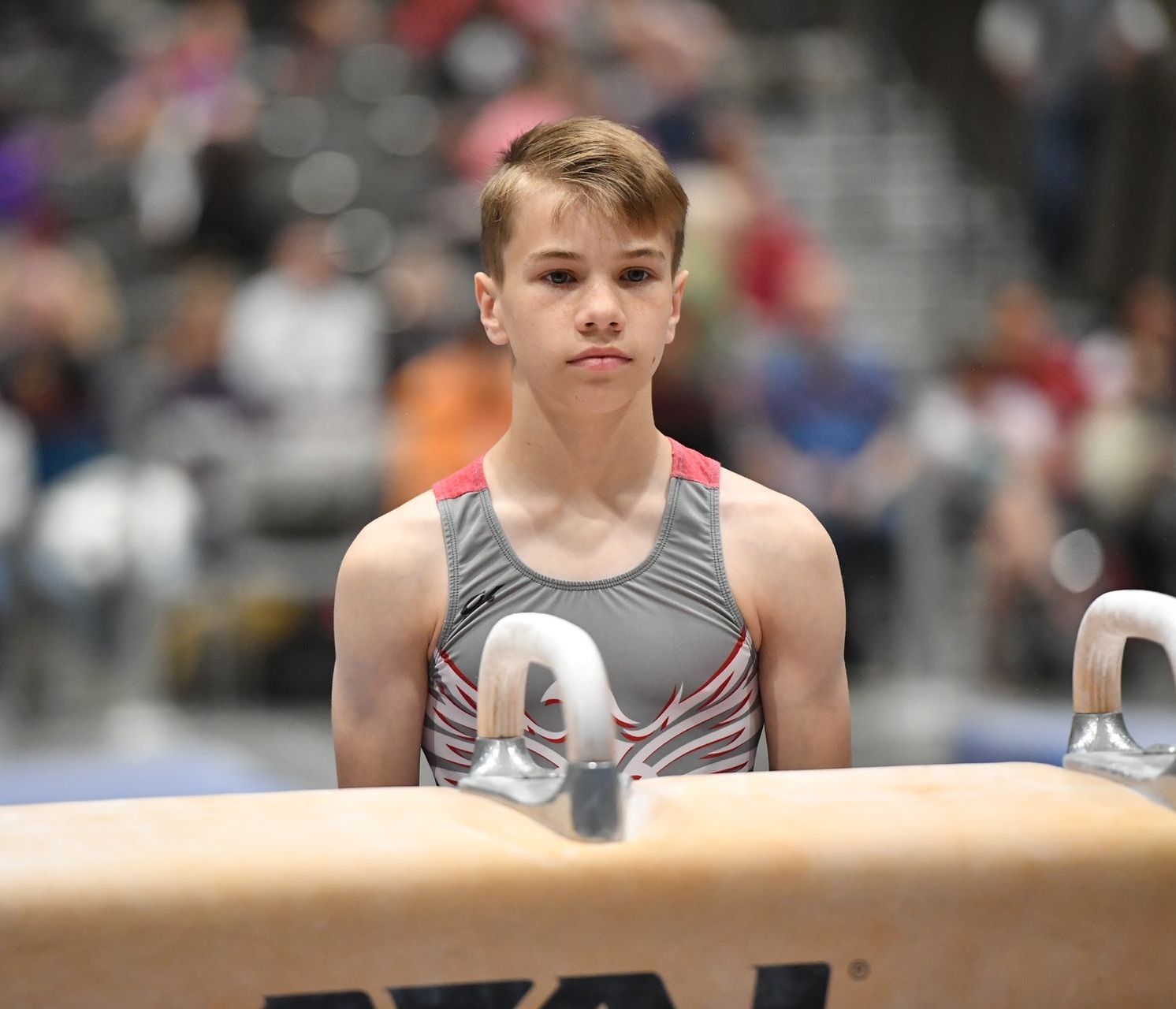 A female gymnast is doing a flip on a trampoline.