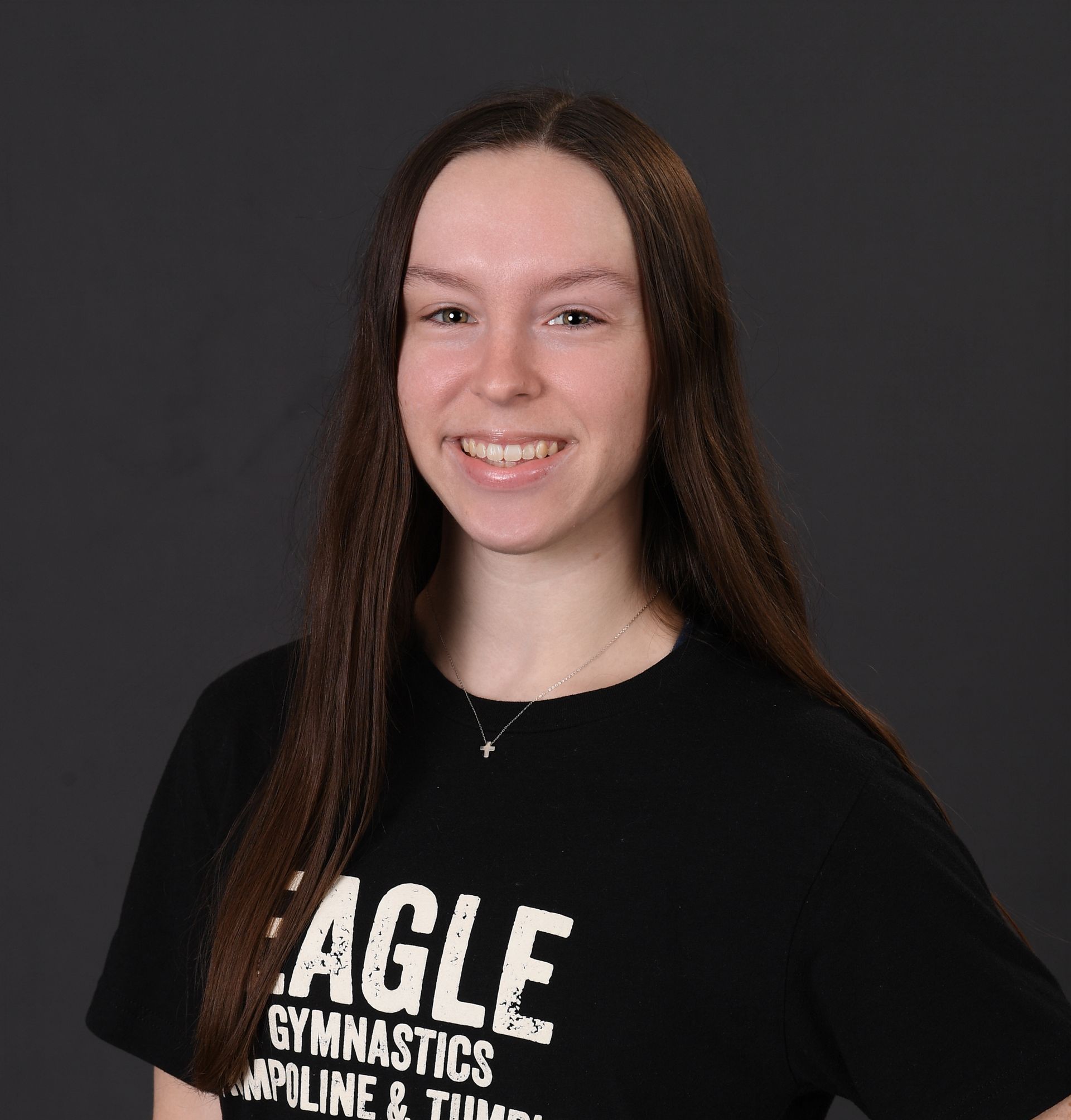 A young woman wearing a black eagle gymnastics shirt