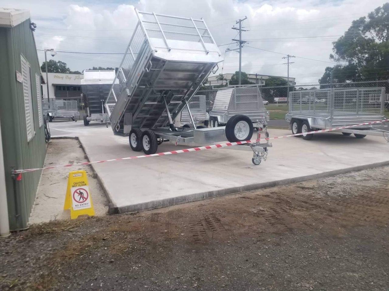 A Raised-bed Trailer Parked on Concrete Near a Building — Drop Deck Trailers In Urangan QLD