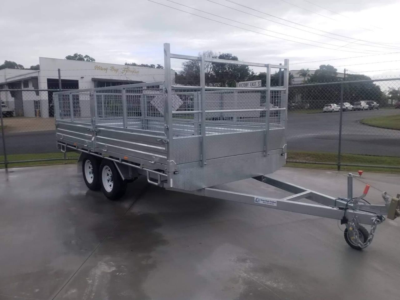 A Trailer is Parked on The Side of The Road in Front of a Building — Drop Deck Trailers In Urangan QLD